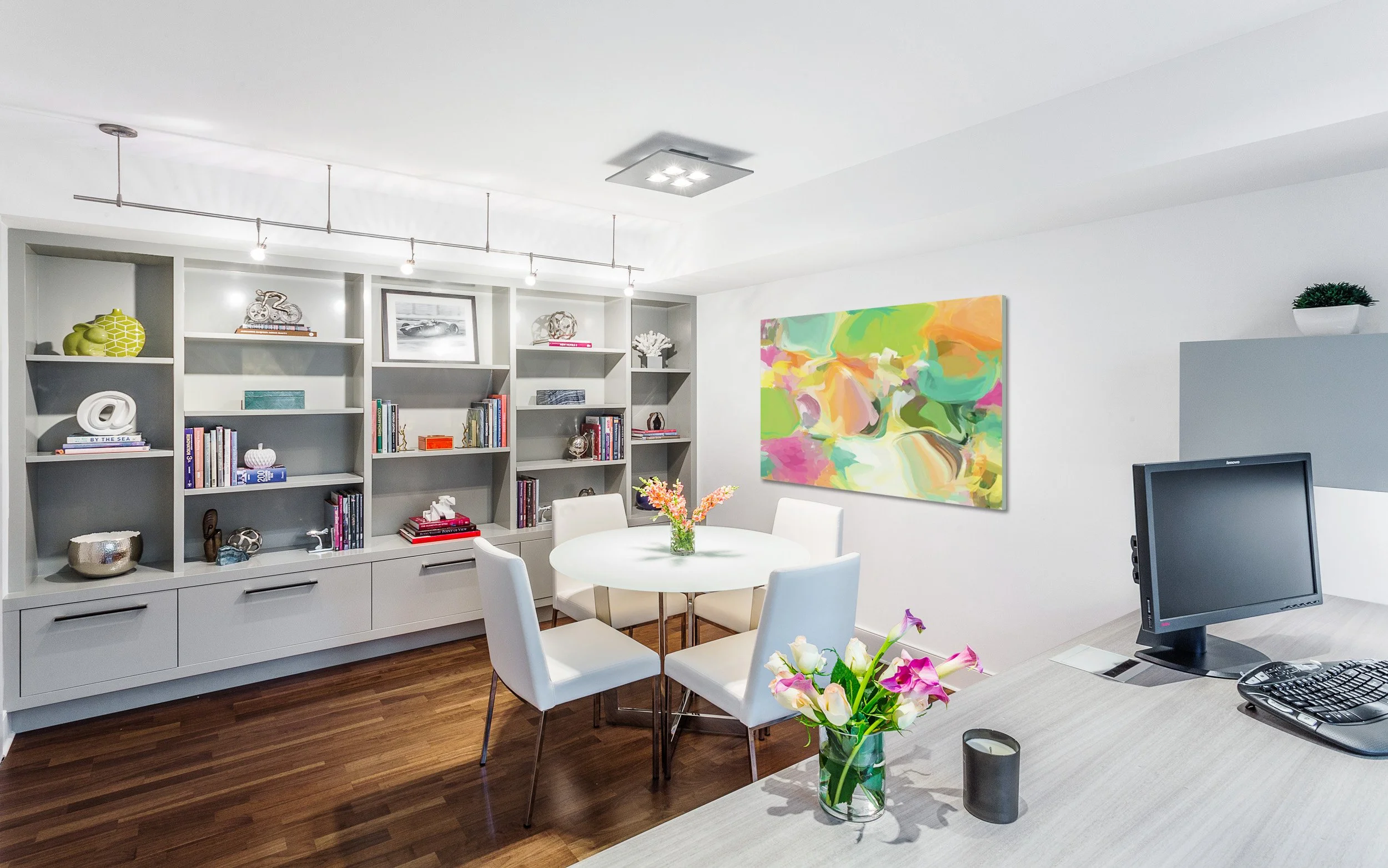 Wide view of a home office with built-in shelving, a round meeting table, and colorful abstract art for a bright, modern feel in Kensett House in Darien, CT.  Designed by Luminosus Designs.