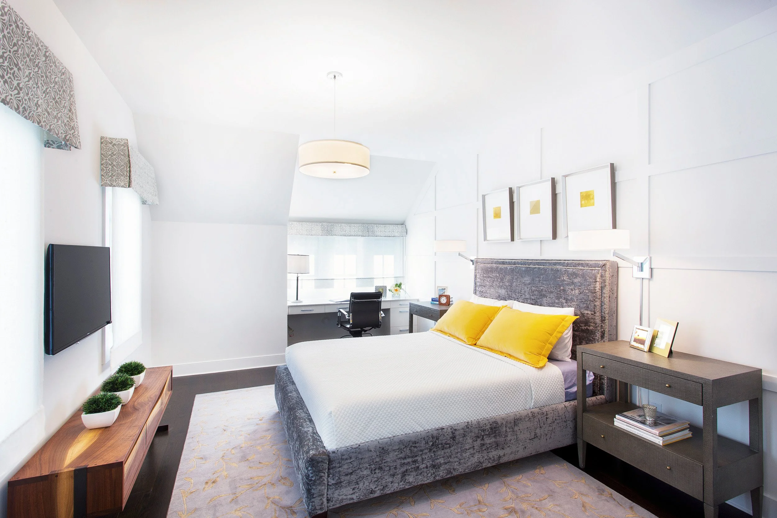 Wide view of a guest bedroom with layered neutral bedding, accent pillows, and a clean, tailored bedside setup in Kensett House in Darien, CT. 