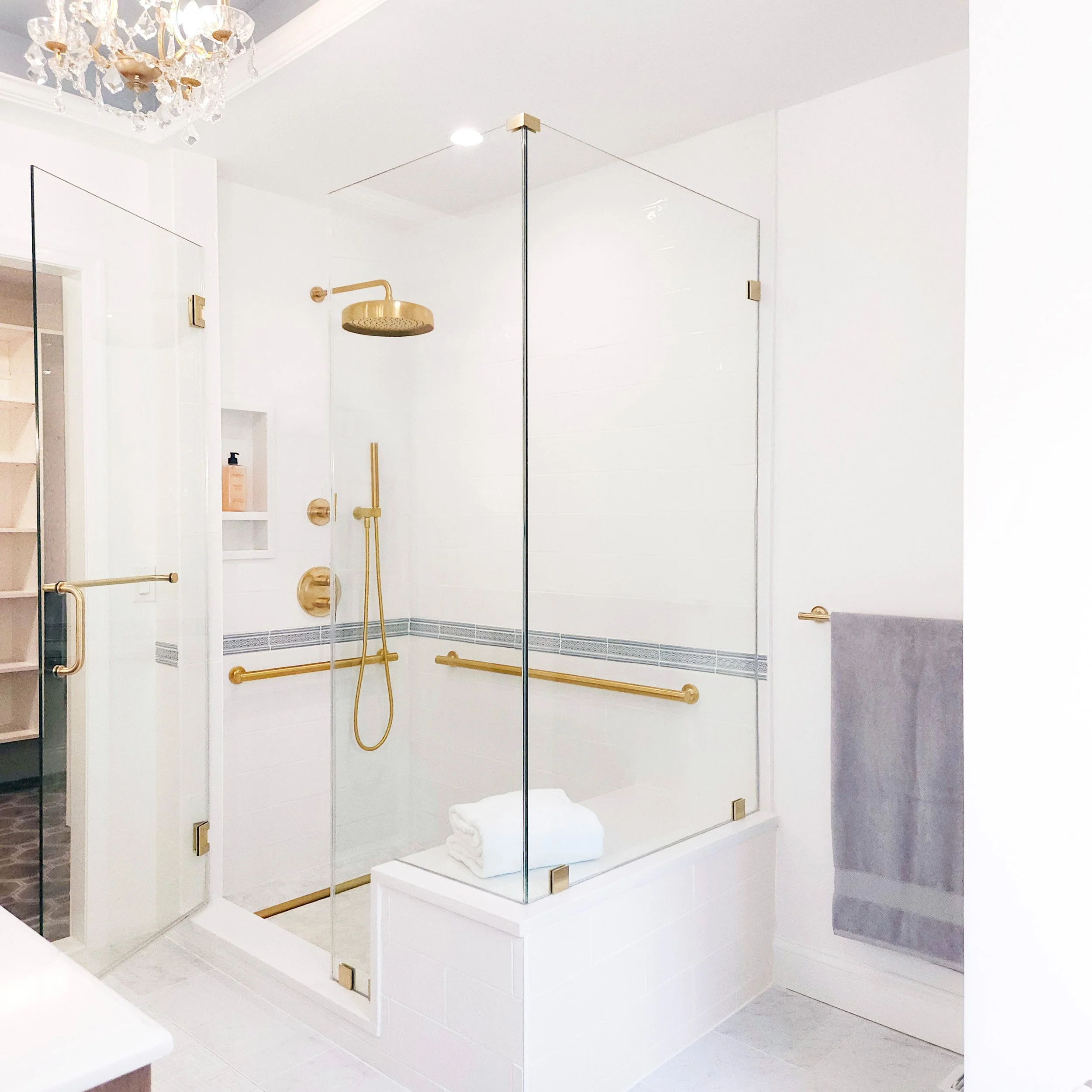 Close-up of shower with brass plumbing fixture and glass enclosure in Carlyle Court in Princeton.