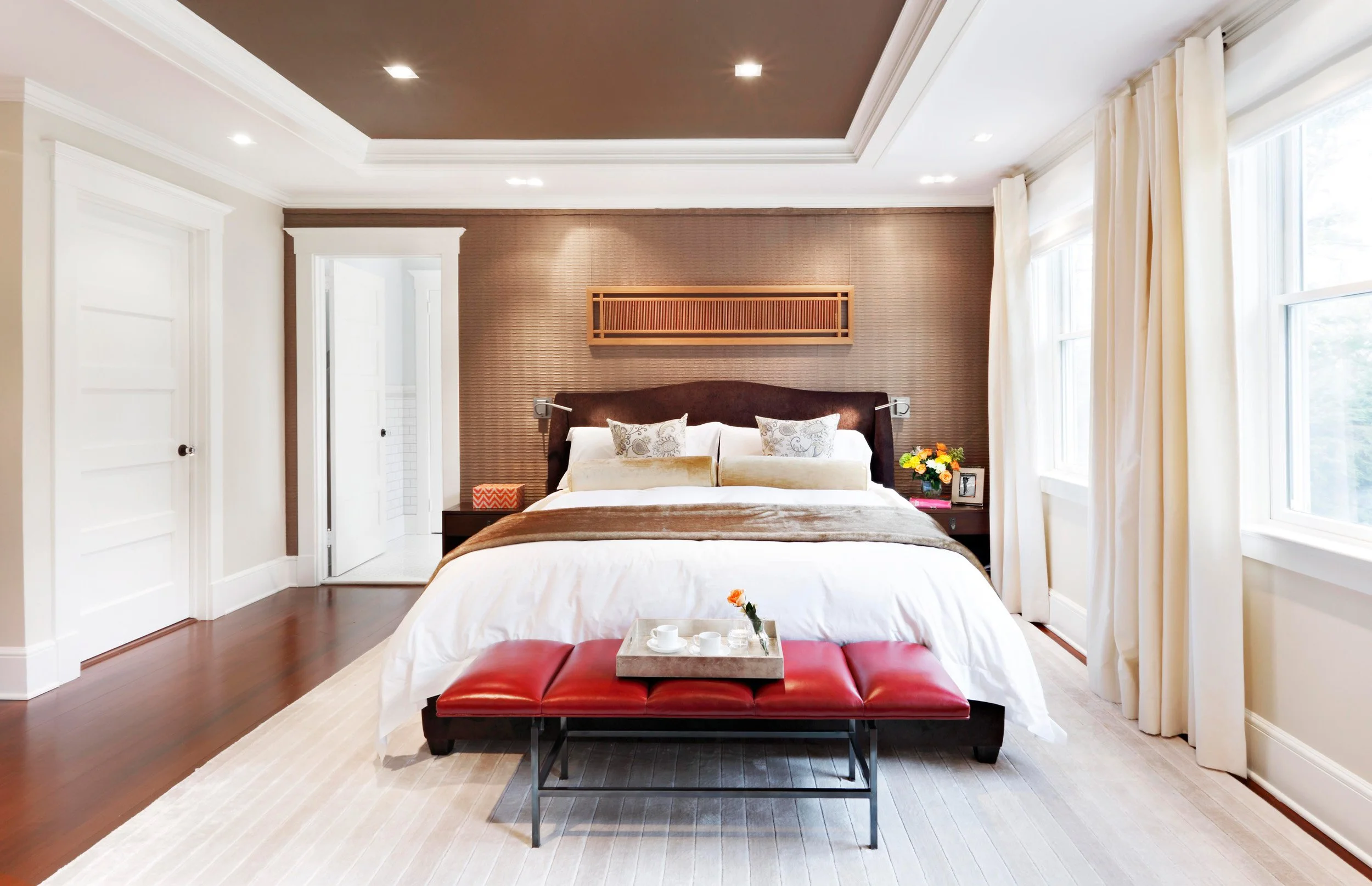 Wide view of primary bedroom with custom window treatments and custom metal frame bench in Indian Field residence in Greenwich, CT.