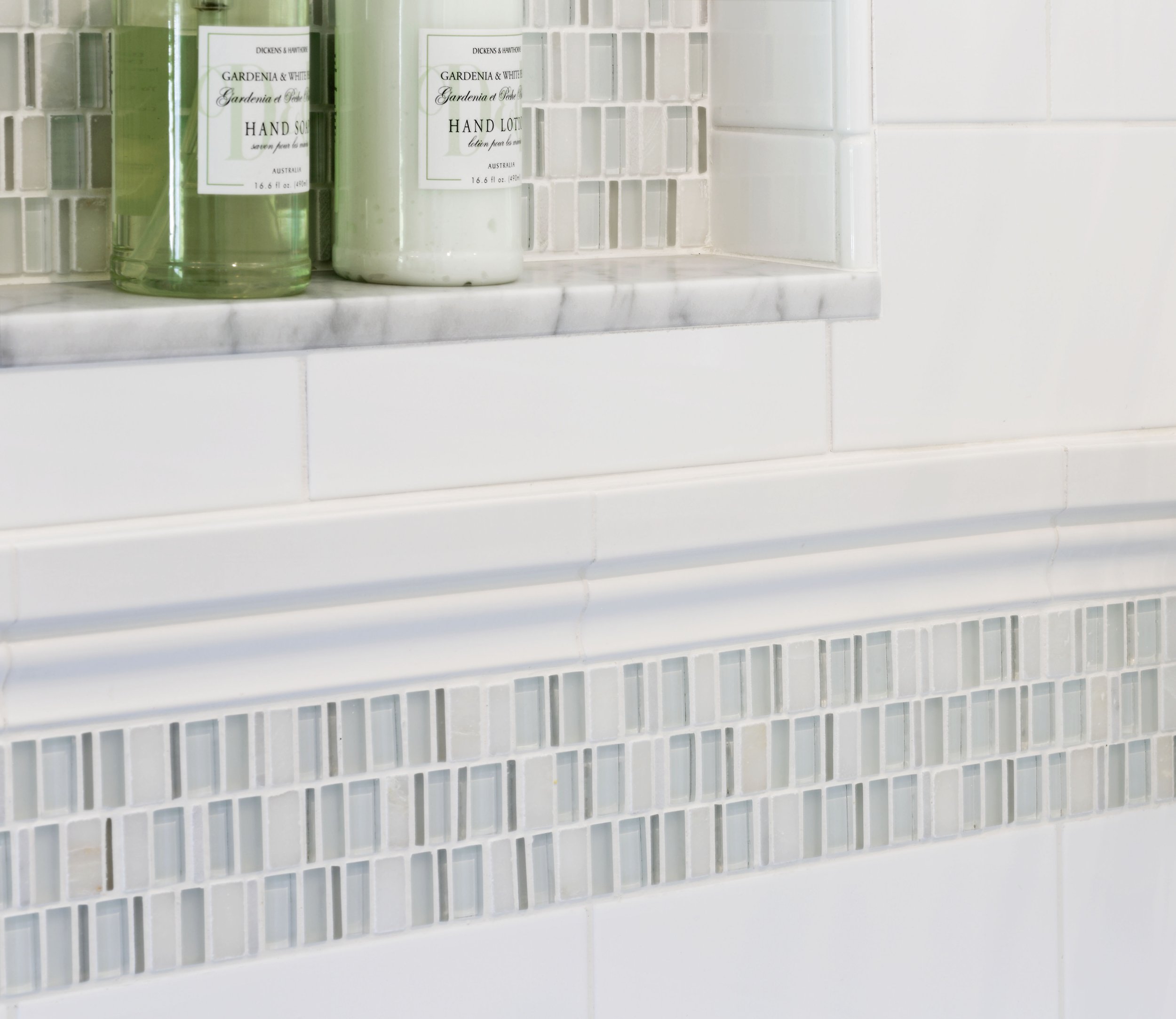 Close-up of white ceramic shower tile and mosaic accent band in a Jack and Jack bathroom at the Dann Farm residence in Pound Ridge, NY.