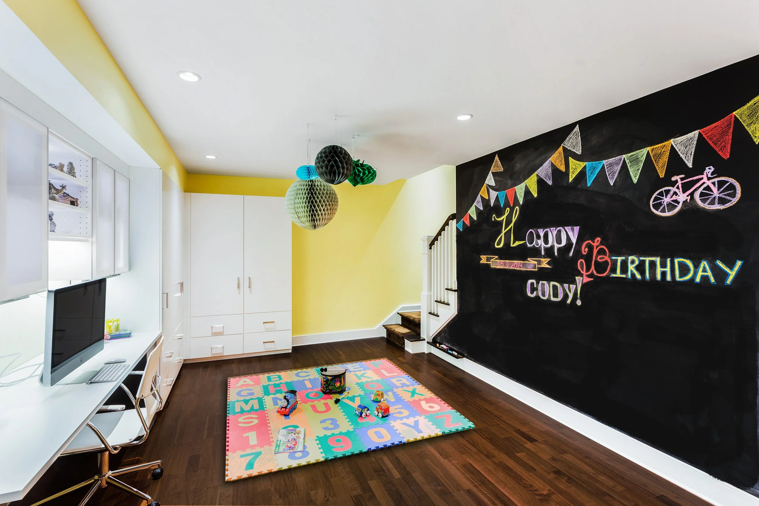 Wide view of a basement play zone with a chalkboard wall, storage, and kid-friendly seating for casual hangouts.