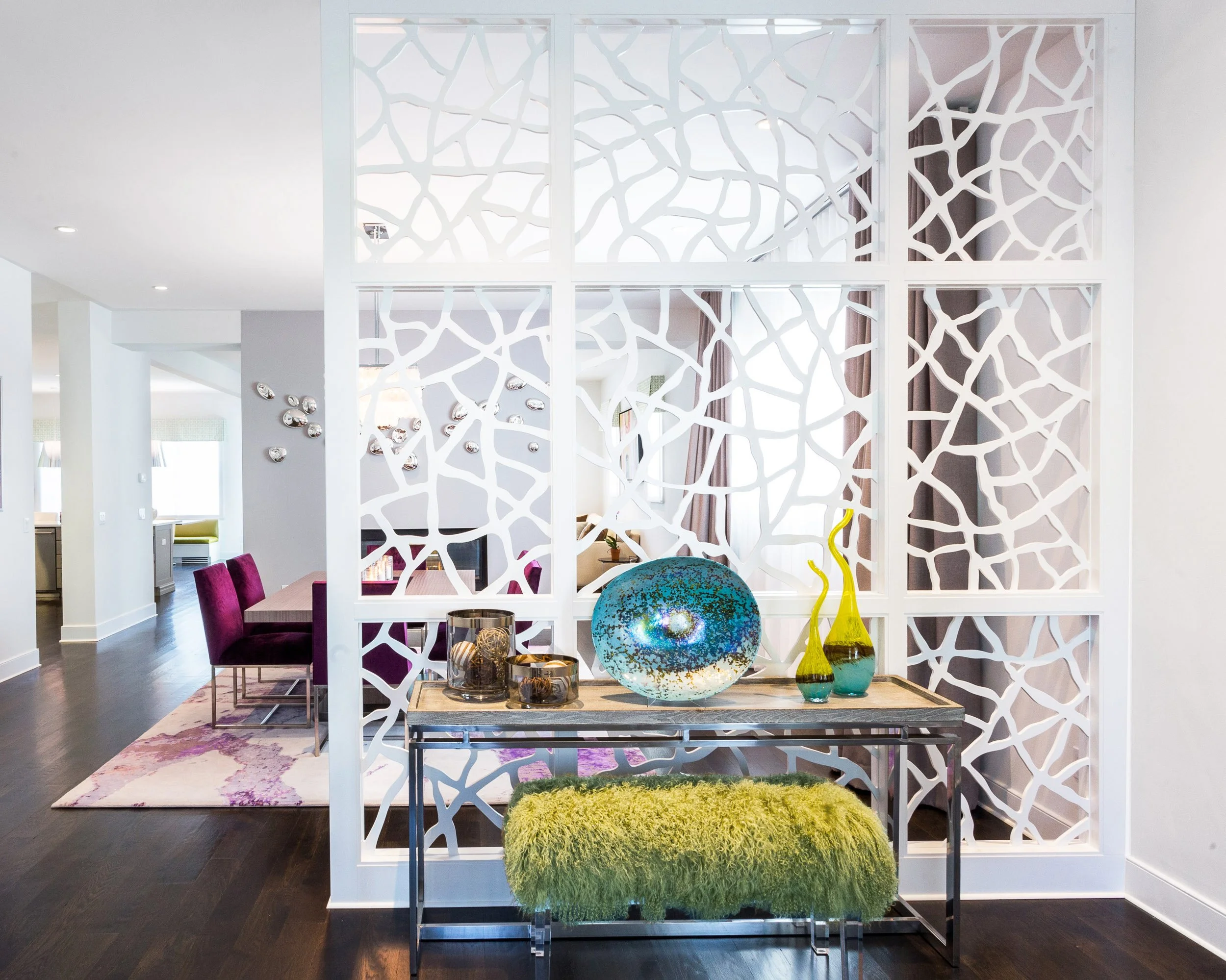 Close-up of the foyer’s laser-cut feature screen with a styled console table, blue glass bowl, and green upholstered bench in Kensett House in Darien, CT. 