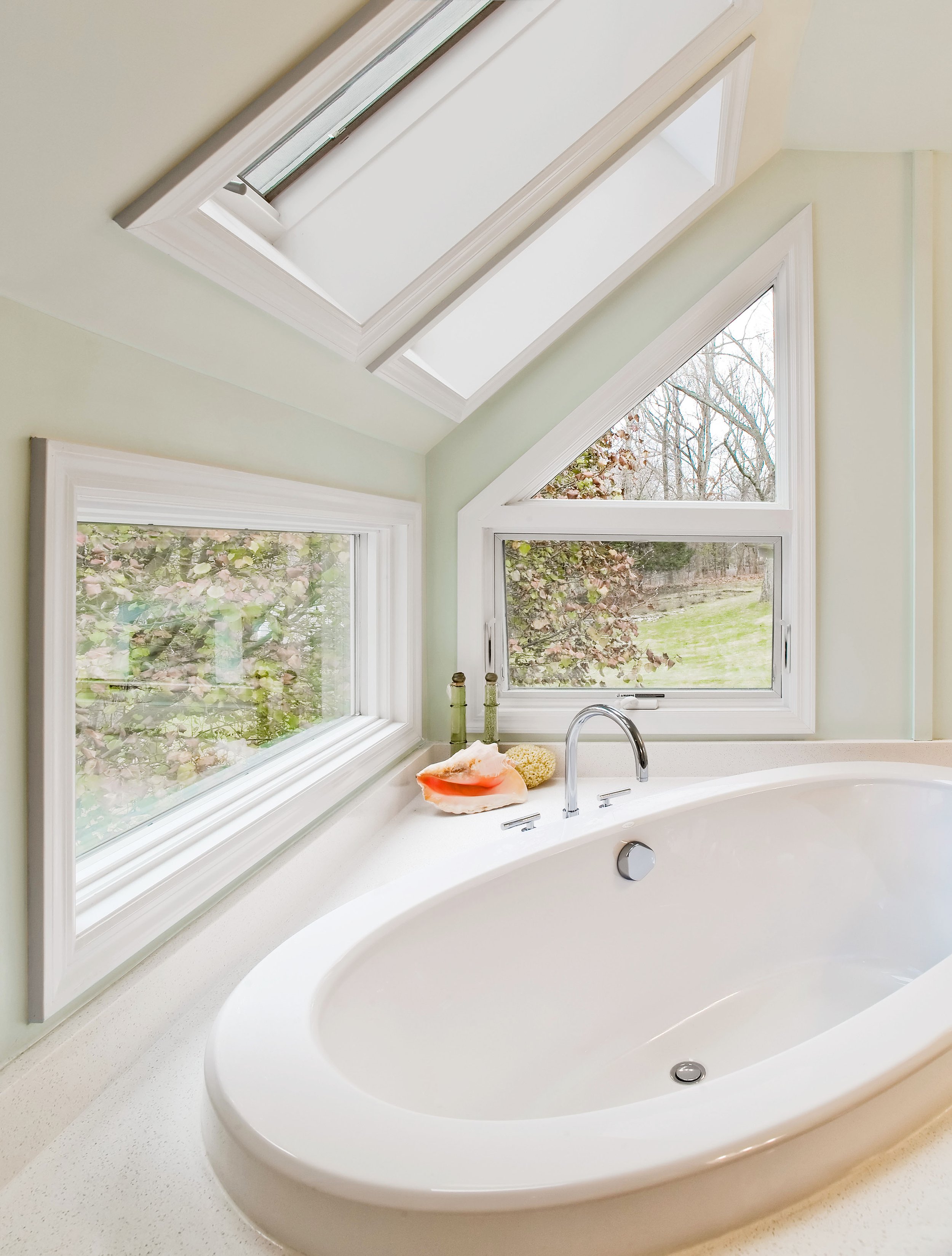 Close-up of a sculptural soaking tub positioned beneath skylights in the Deerfield primary bathroom in Pleasantville, NY.