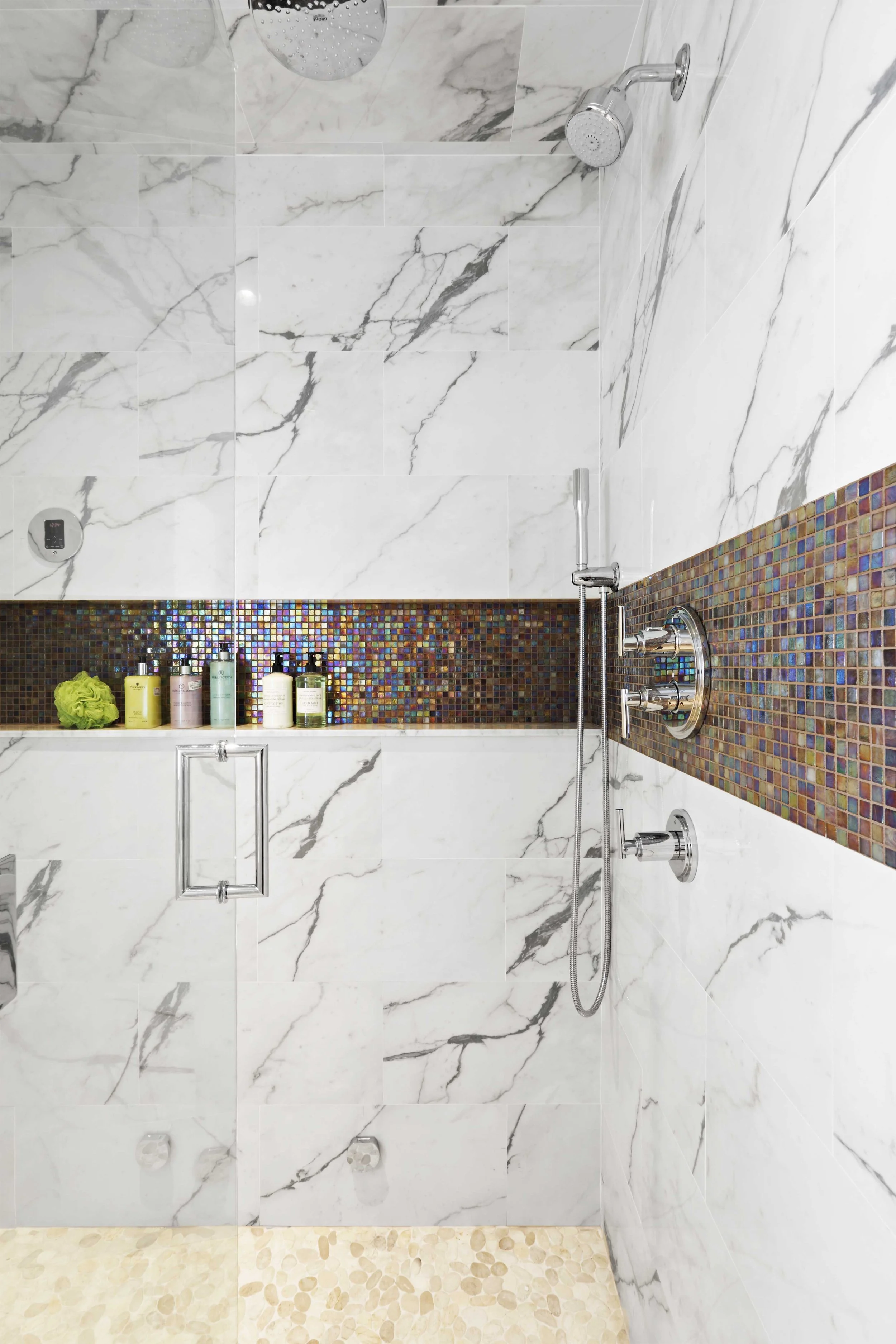 close-up view of the shower niche and mosaic accent tile in a primary bathroom in Old Briarcliff, NY.