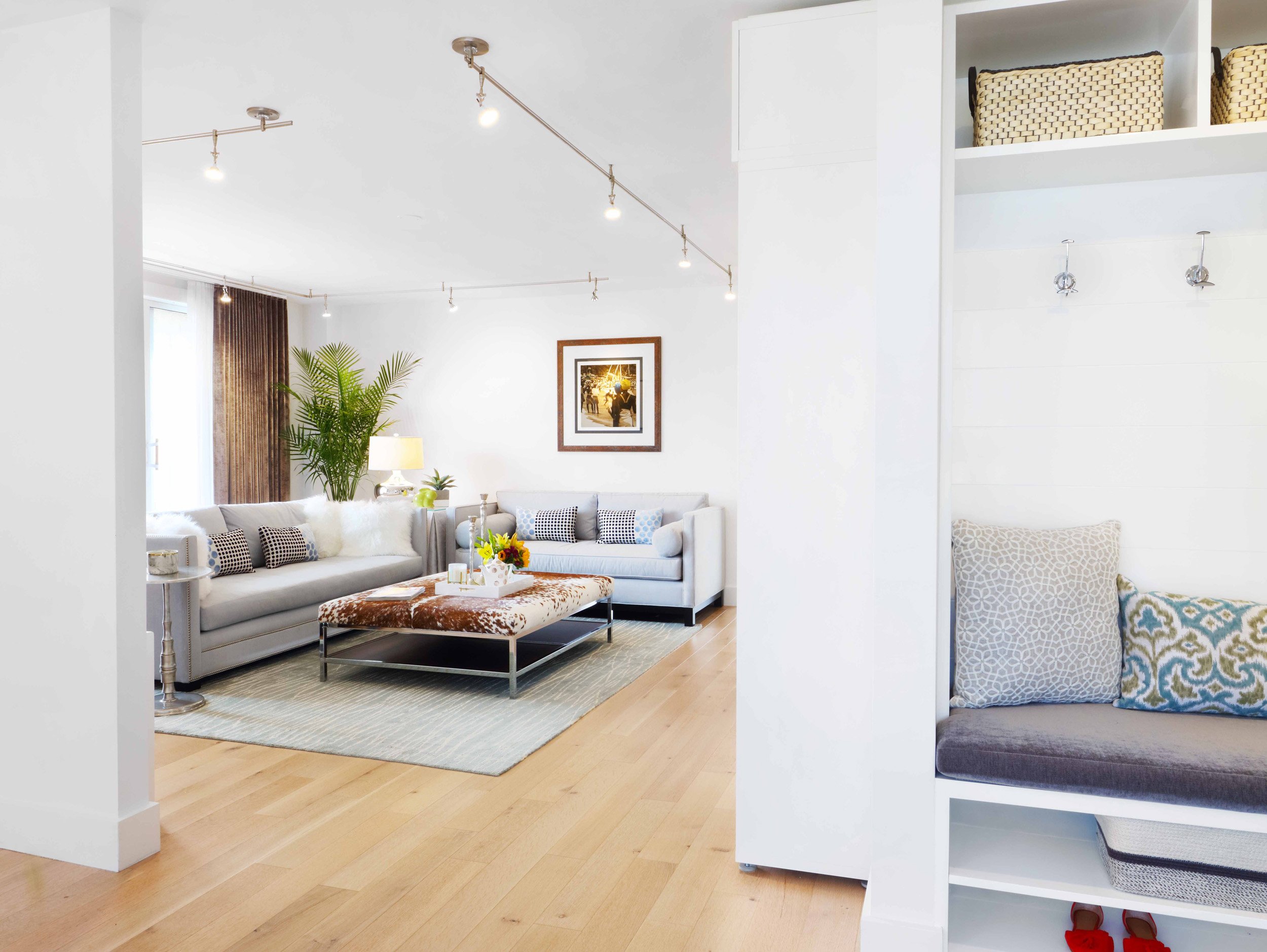Bright White Plains apartment living room with upholstered sofas, patterned pillows, and layered textures in a light-filled setting.