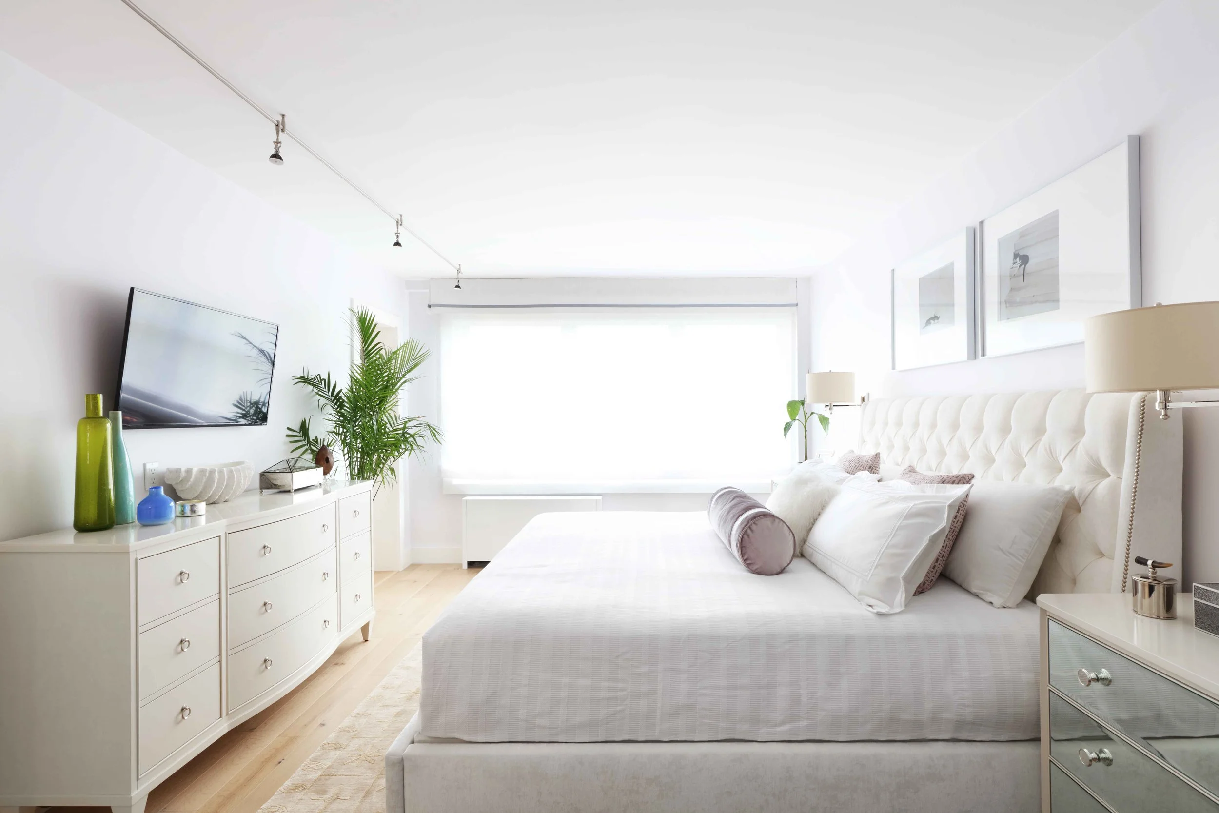 Serene primary bedroom with upholstered headboard, layered bedding, and soft neutral tones in Doyer Apartment in White Plains, NY.