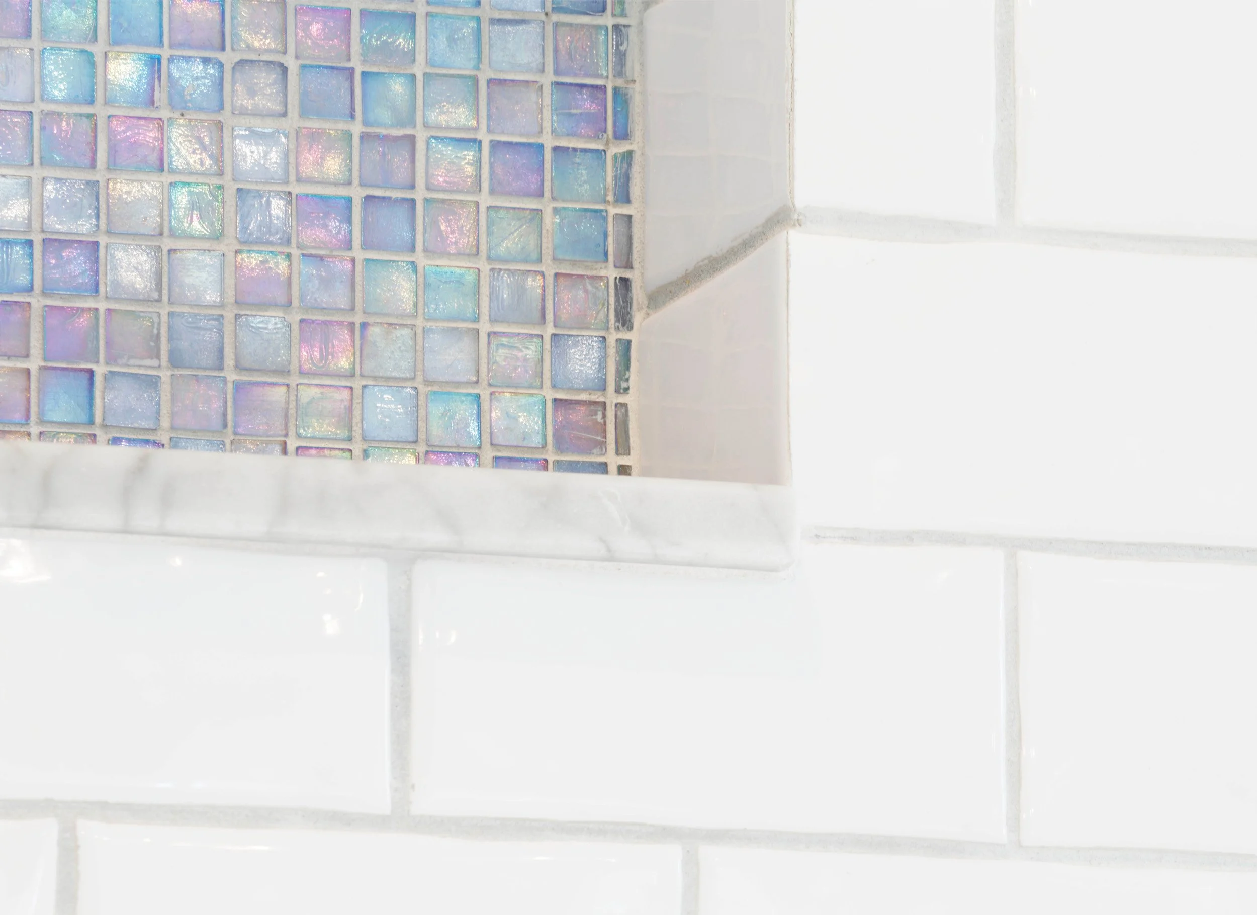 Close-up of tiled shower niche with iridescent mosaic in primary bathroom in Greenwich, CT.