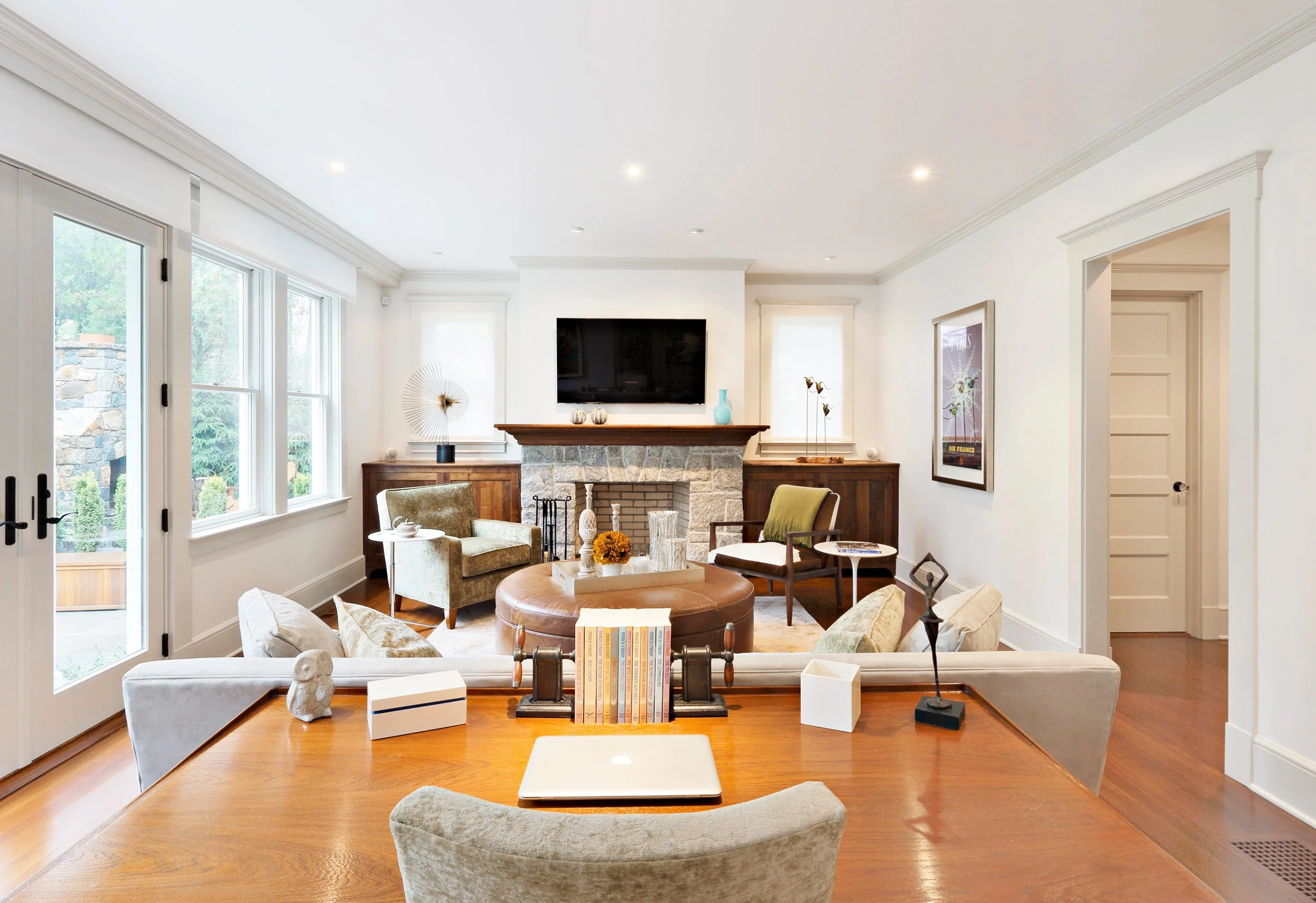 Wide view of family room in Indian Field residence in Greenwich, CT featuring vintage writing desk and custom furnishing by Luminosus Designs.