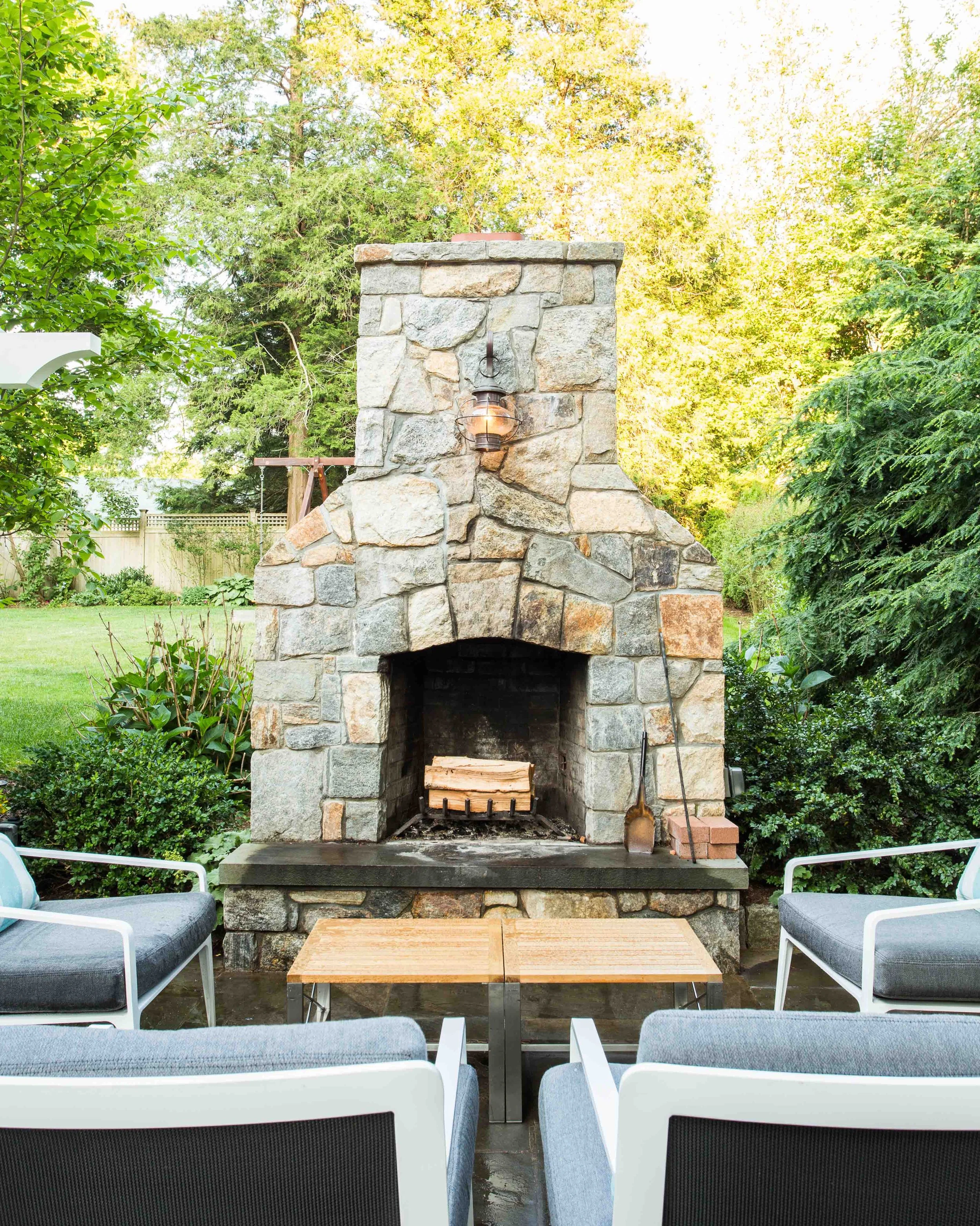 close-up view of furniture and stone fireplace in the outdoor lounge area at the Indian Field Outdoor project in Greenwich, CT.