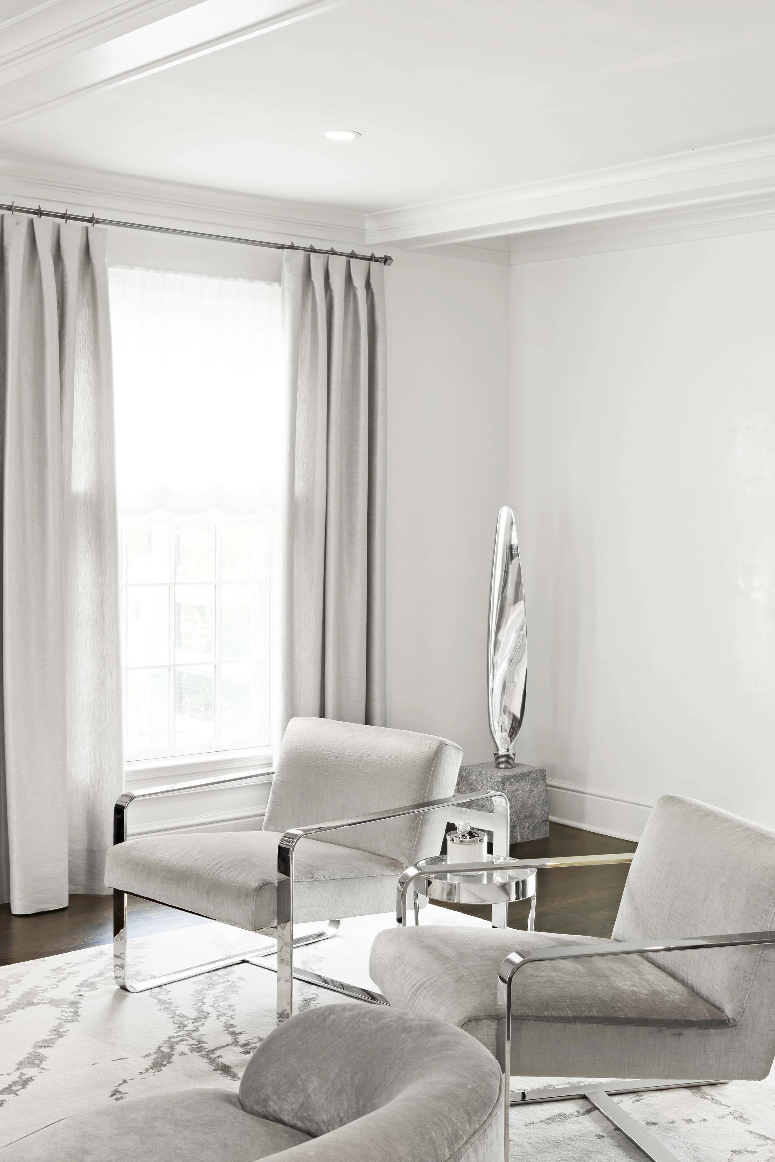 Accent seating area in the living room at the Meeting House in Greenwich, CT with upholstered chairs and chrome detailing.