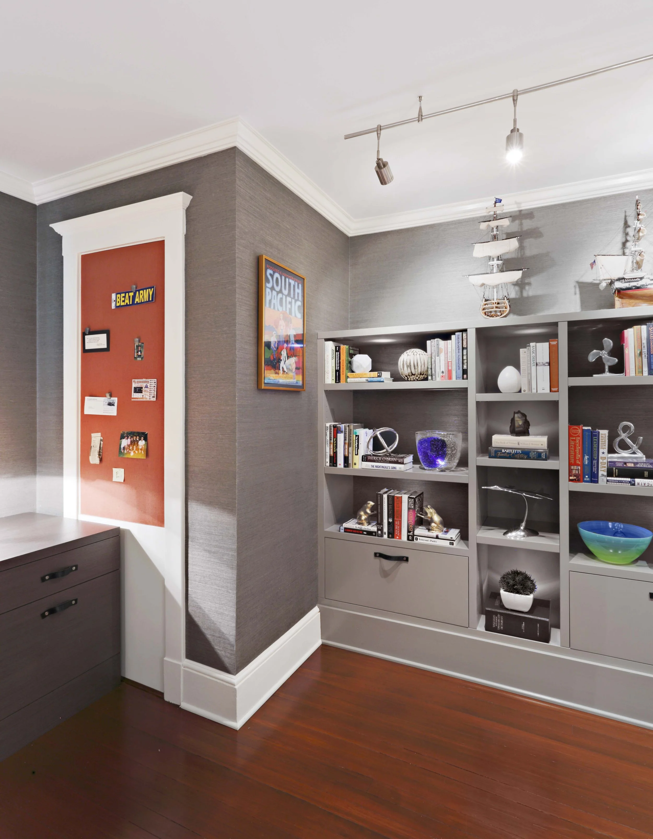 Custom bookcase and pin-up board integrated into home office wall.