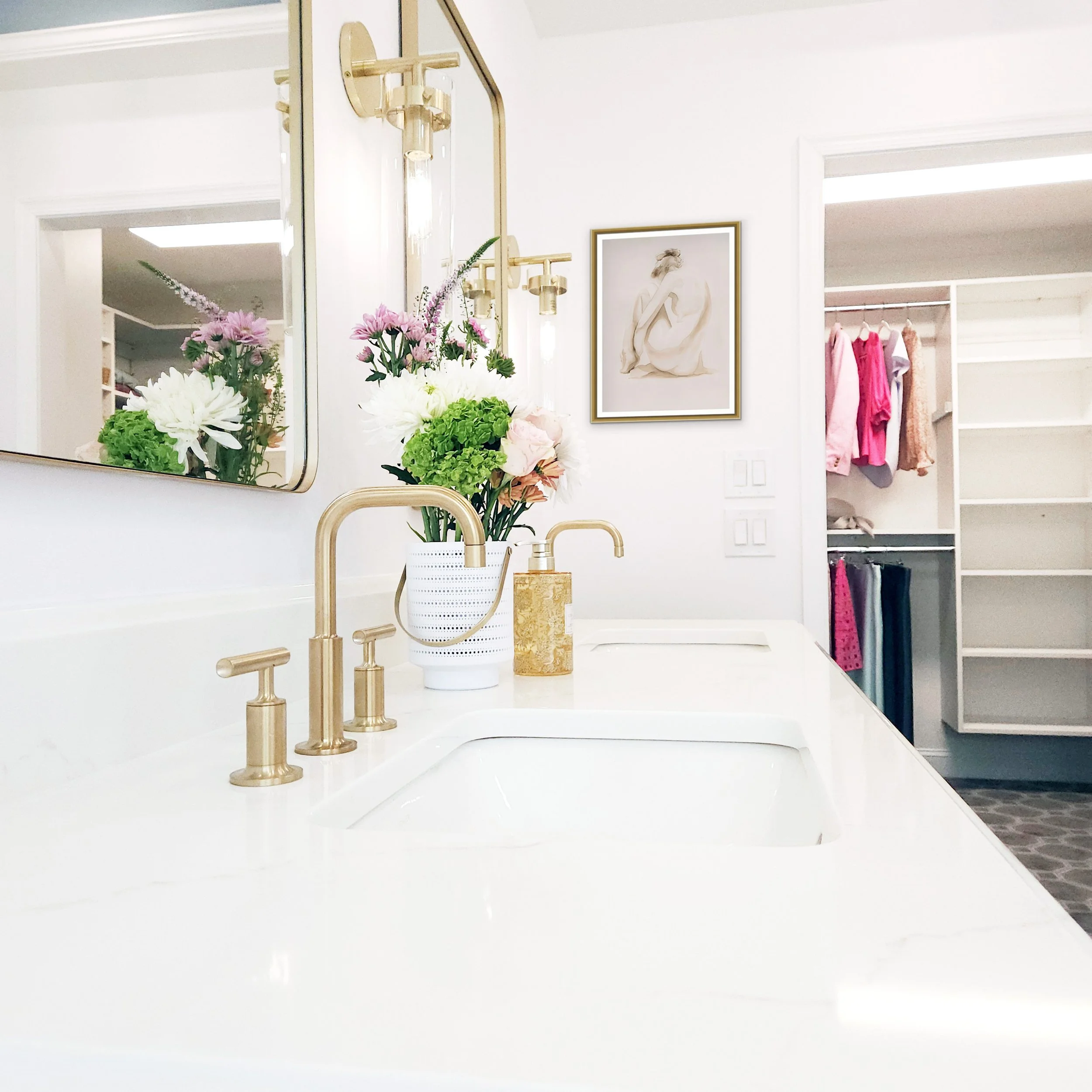 Close-up view of Vanity faucet and quartz countertop with brass fixtures in Carlyle Court in Princeton, NJ primary bathroom.