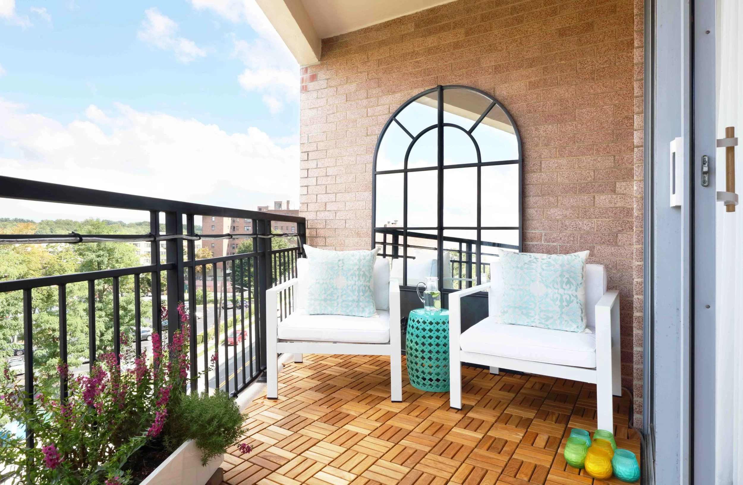 Balcony detail featuring outdoor furnishings and greenery in Doyer Apartment in White Plains, NY.