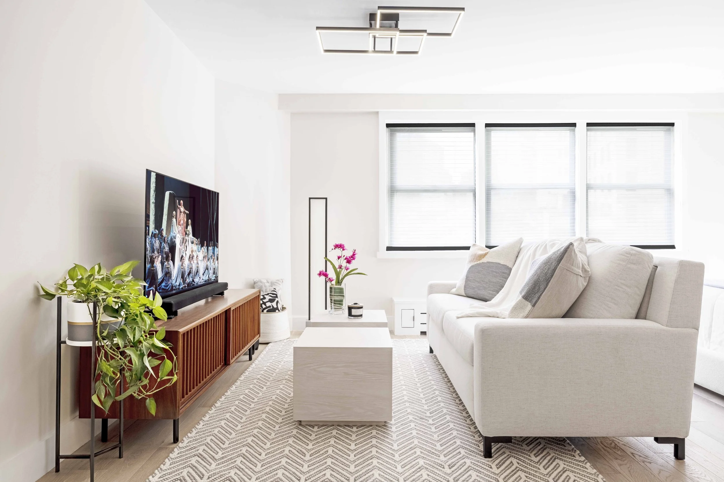 Close-up view of calm living area featuring sleeper sofa, movable coffee tables, and media console in the Gramercy Arms apartment, NYC by Luminosus Designs.
