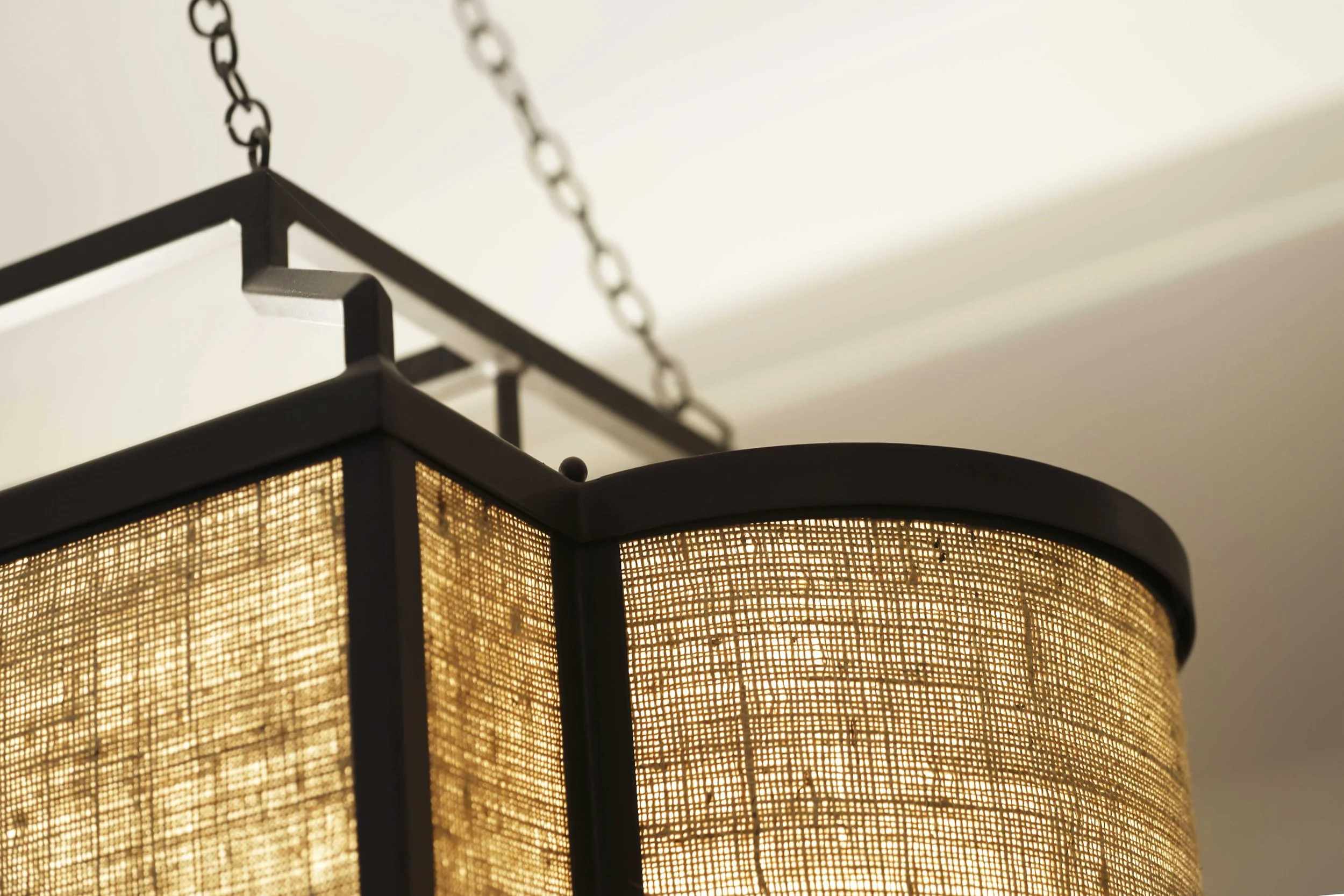 Close-up of sculptural chandelier anchoring the dining room seating area.