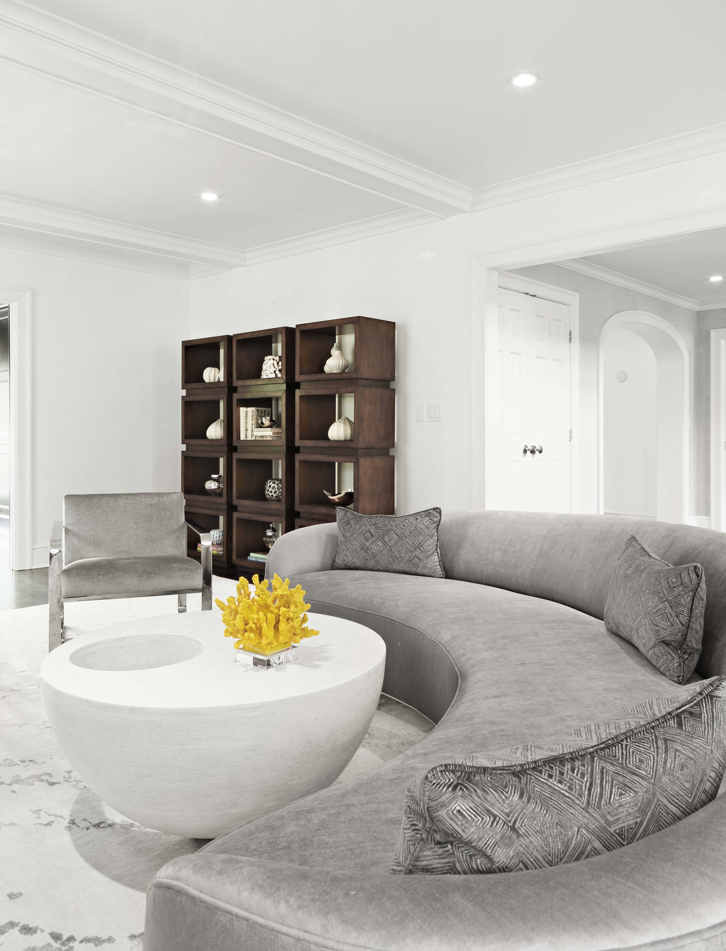 Living room seating arrangement at the Meeting House in Greenwich, CT featuring curved upholstery and custom shelving.