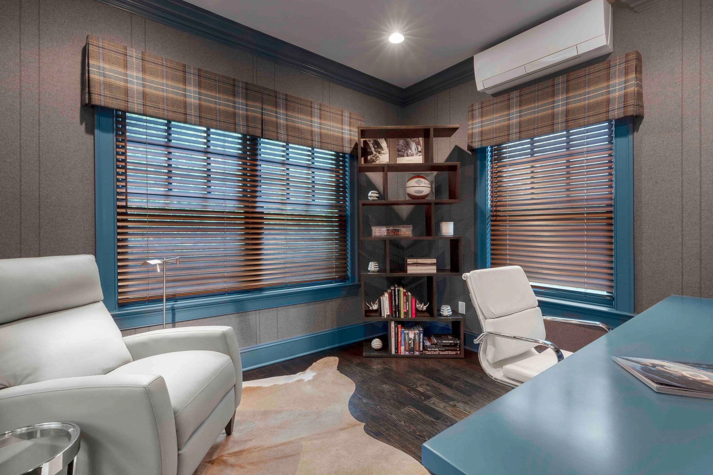 Close-up of the bookcase, window treatment, and reclining chair in the Glen Oaks home office in Rye, NY.
