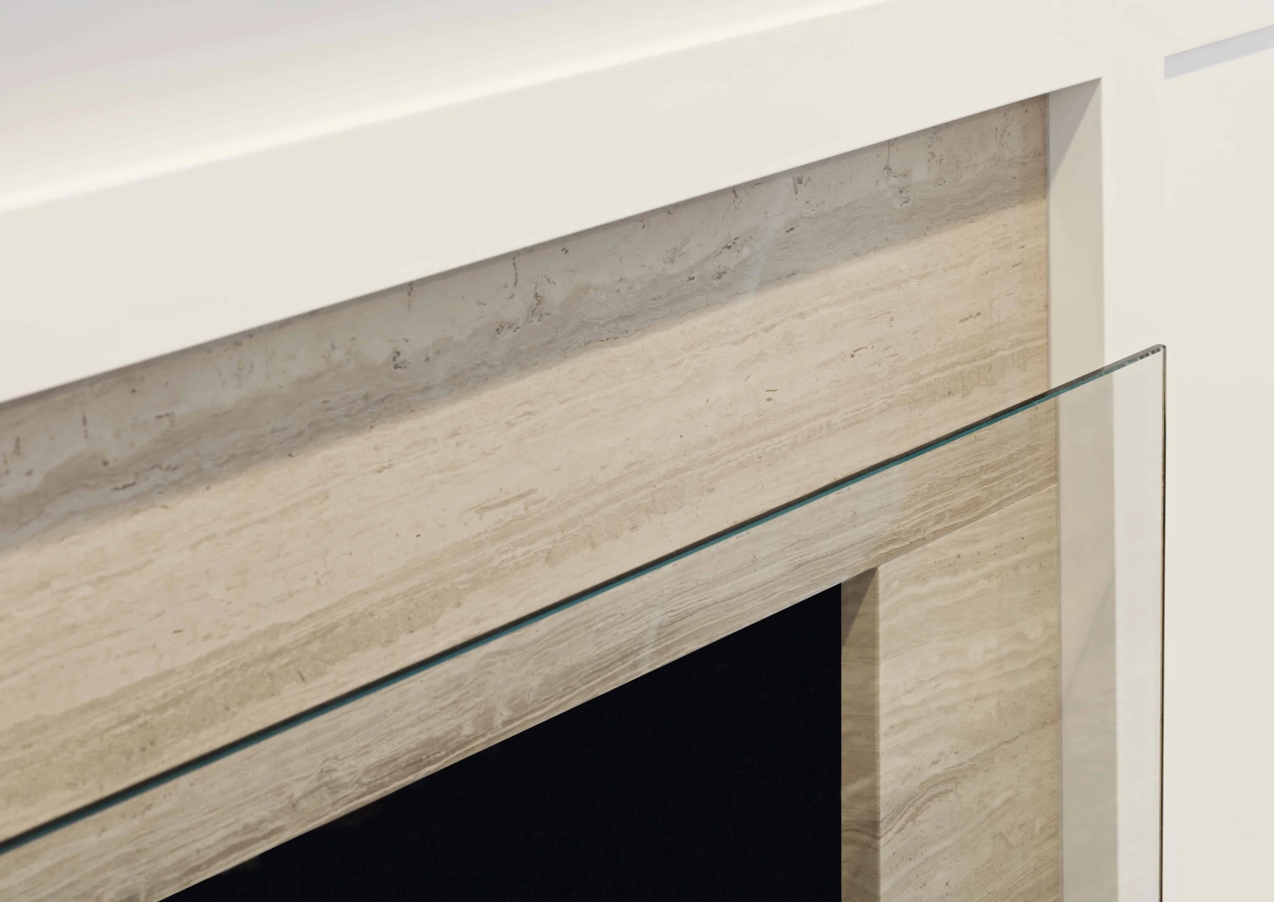 Detail view of the custom fireplace surround with stone detailing and clean architectural lines in a family room.