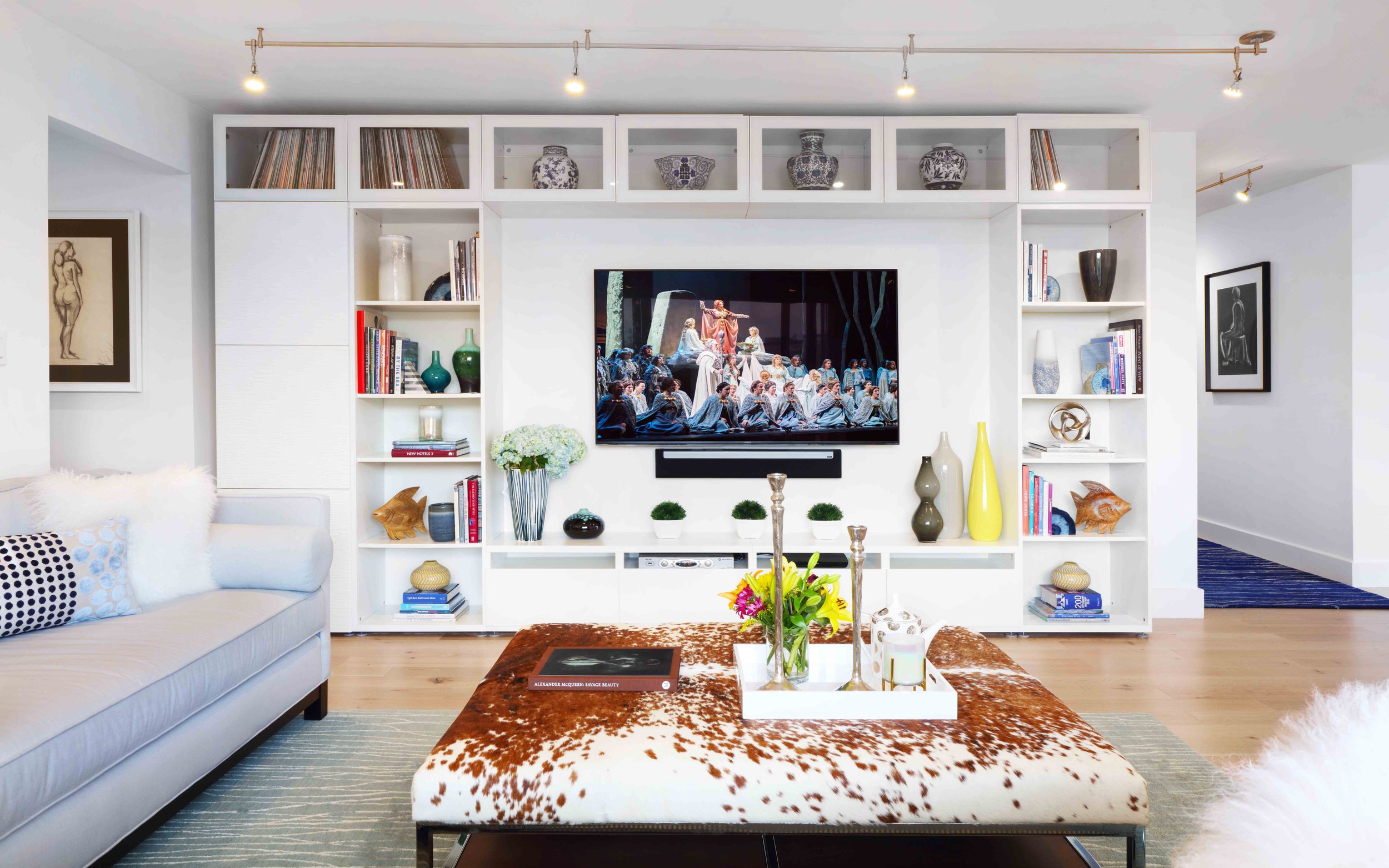Living room with custom media cabinet, neutral palette, and layered furnishings in Doyer Apartment in White Plains, NY.