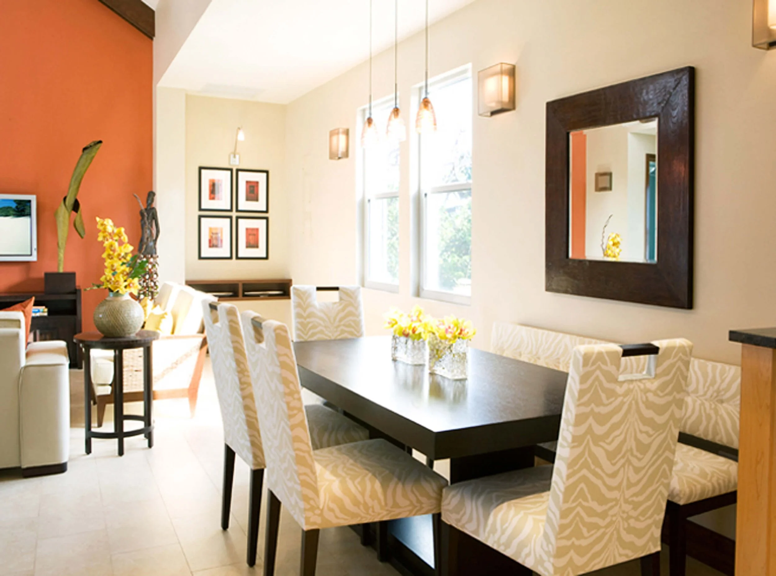 Open plan dining and living area in Grand Cayman guest villa with natural light and warm palette.