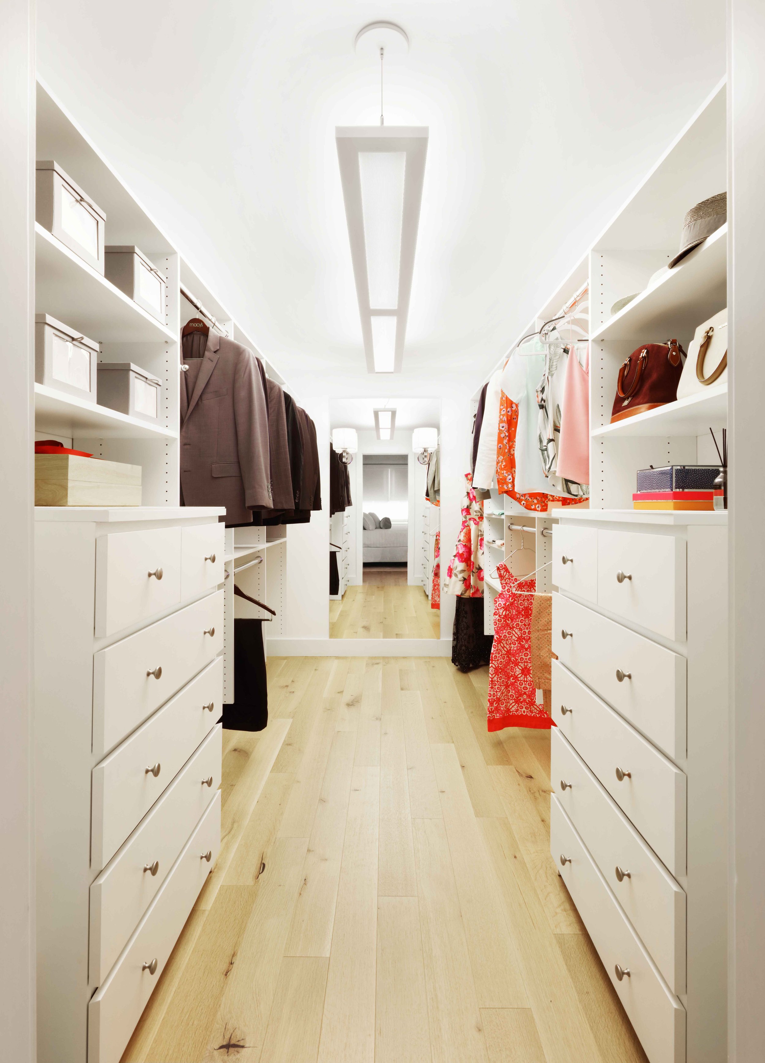 Custom walk-in closet with built-in shelving, drawers, and integrated lighting