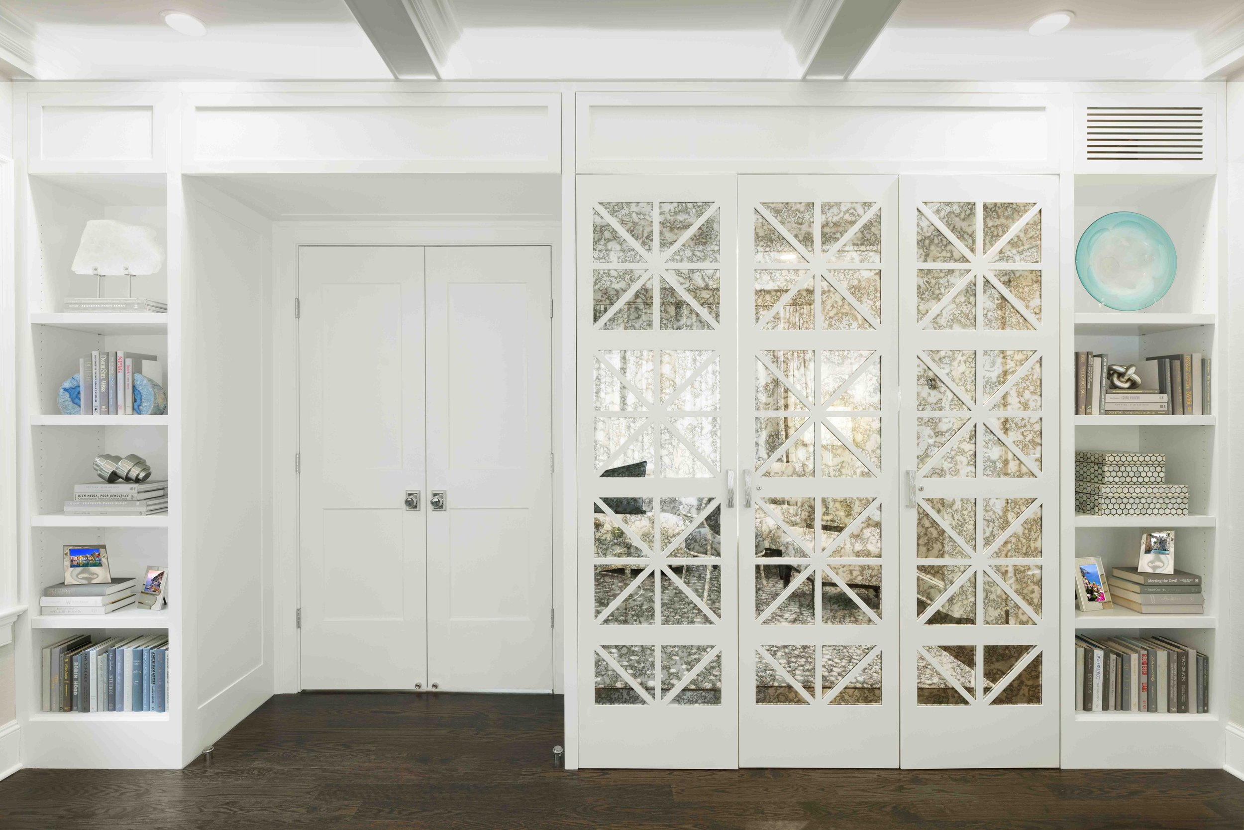 Close-up view of the custom bookcase and hidden bar cabinet in the Glen Oaks, Rye, NY living room, showing surround and finish details.