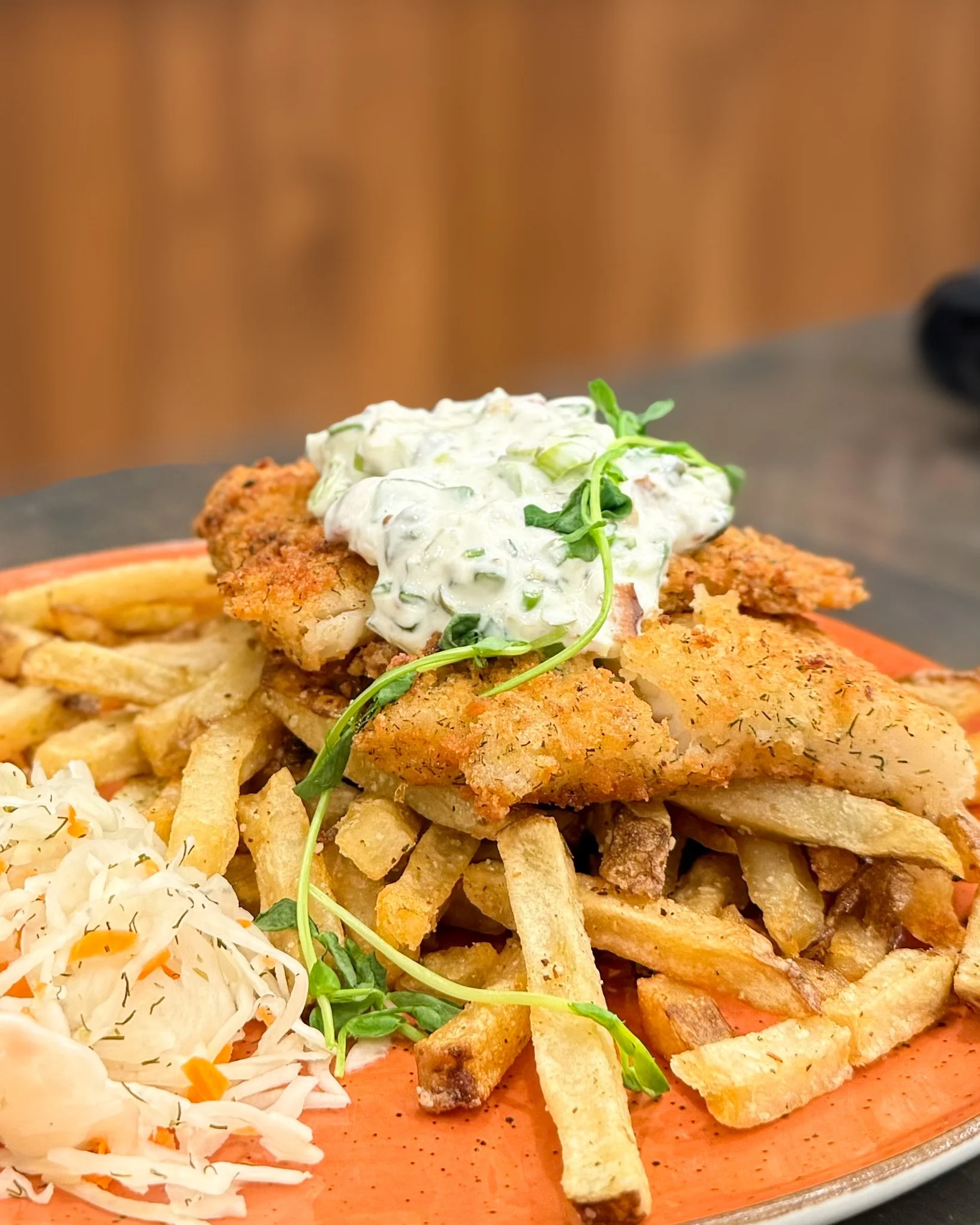🍽️ A classic, done our way! 🌊✨ 

Indulge in our mouthwatering Fish &amp; Chips: 
🐟 Lemon dill panko-crusted, pan-fried cod 
🥓 Bacon &amp; green onion tartar sauce 
🍟 Fresh-cut fries 
🥬 Pickled slaw 

Available for lunch and dinner! 

#FishAndCh
