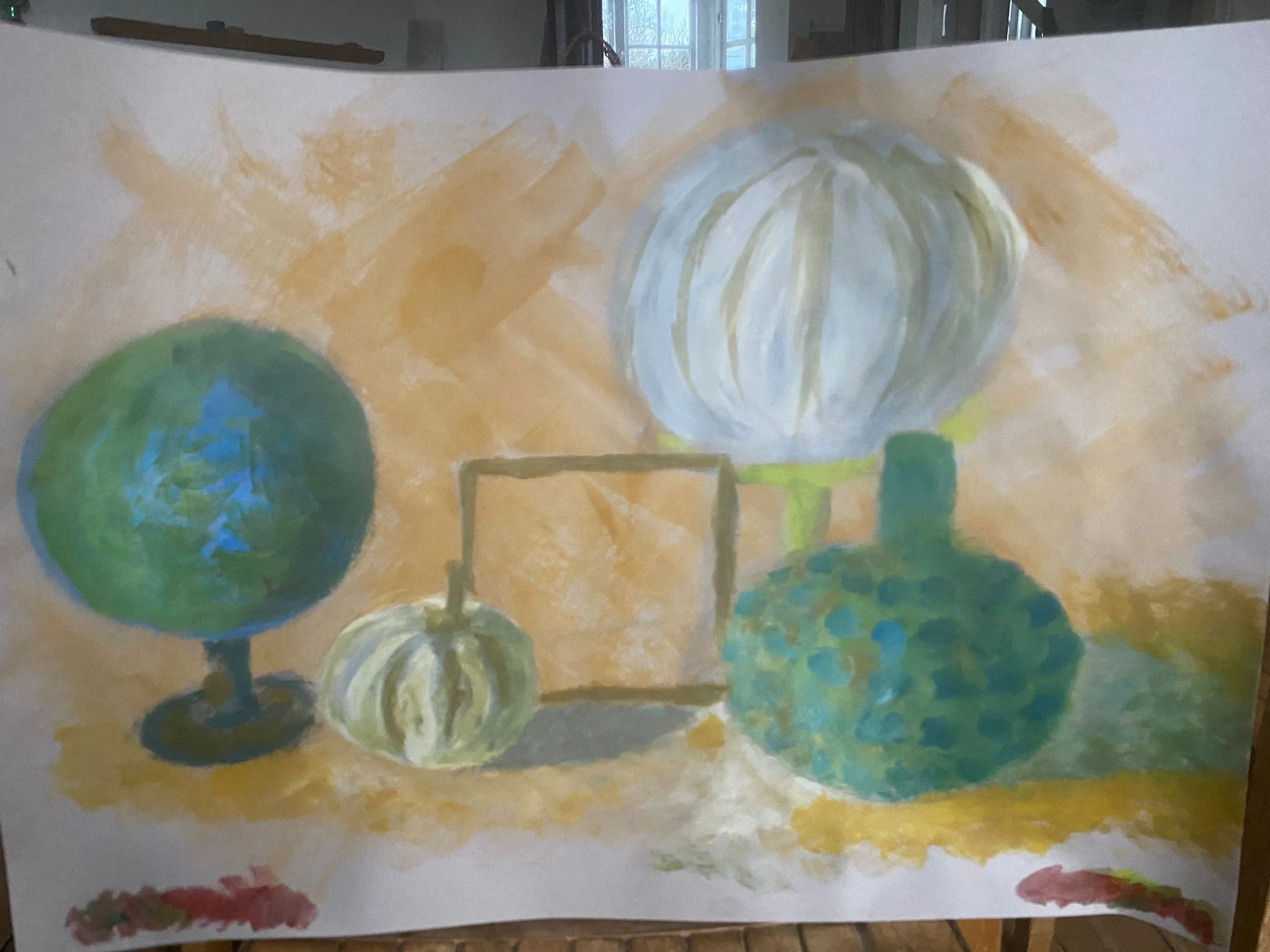 A watercolor painting of five objects on a table. Two globes, one larger and one smaller, painted in shades of green and blue, and three round objects resembling pumpkins, painted in white, yellow, and green. The background has broad orange brushstro