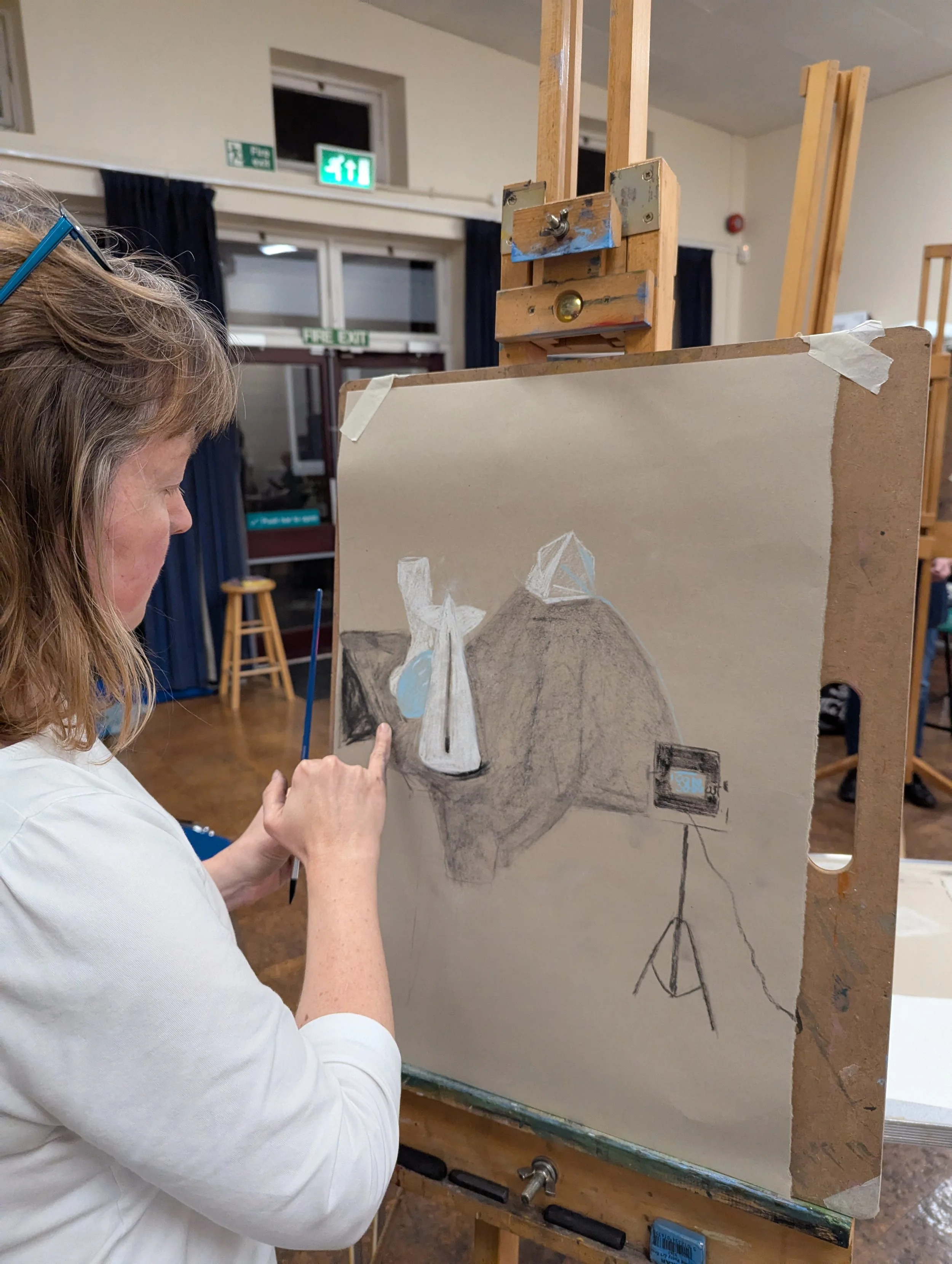 Student painting on a canvas set on an easel in an art studio