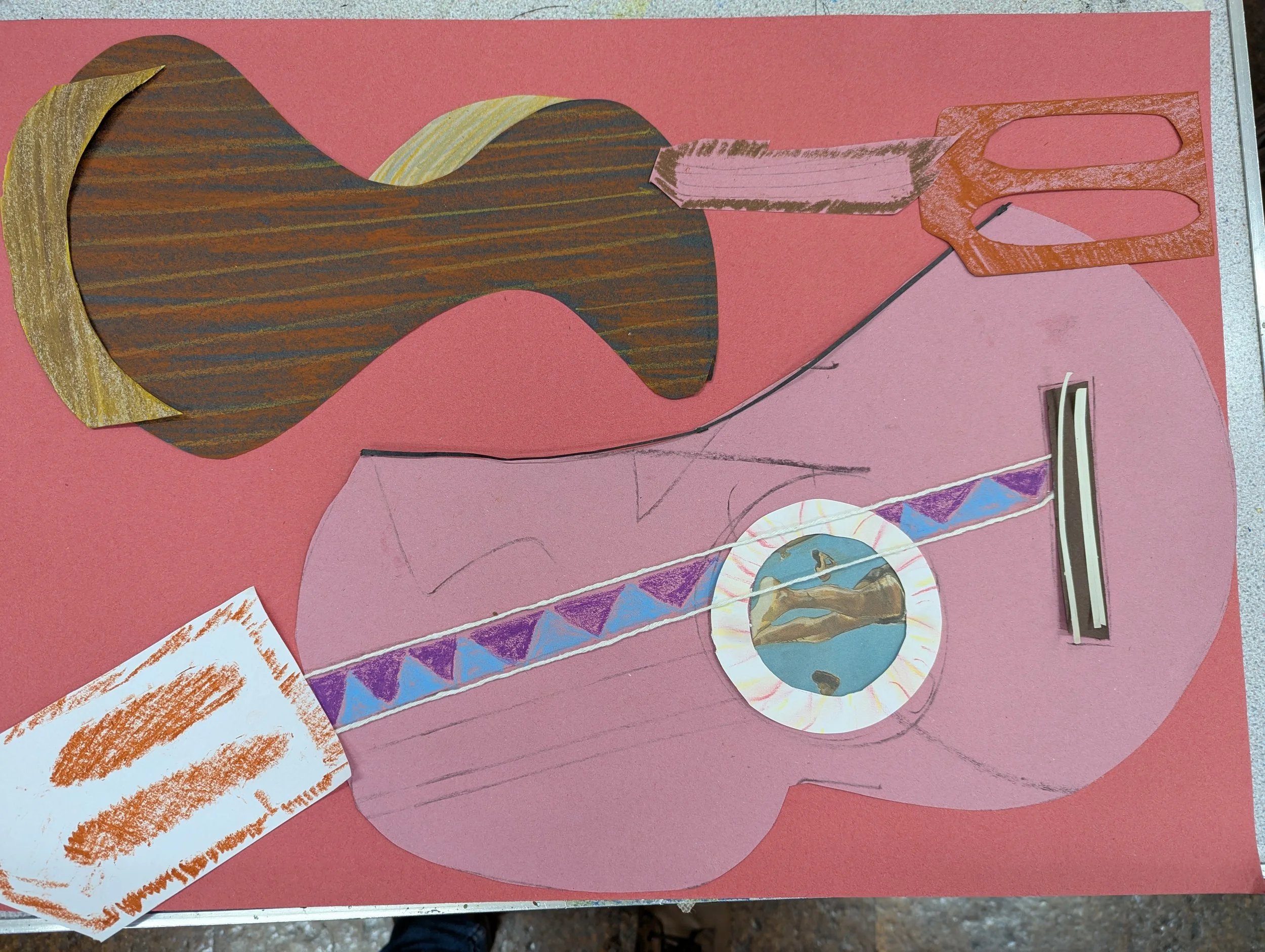 A collage featuring a paper guitar with colourful decorations, including a geometric patterned strip, a circular element with a landscape image, a paper cutout of a beard, and a small square with orange markings, all on a pink background.