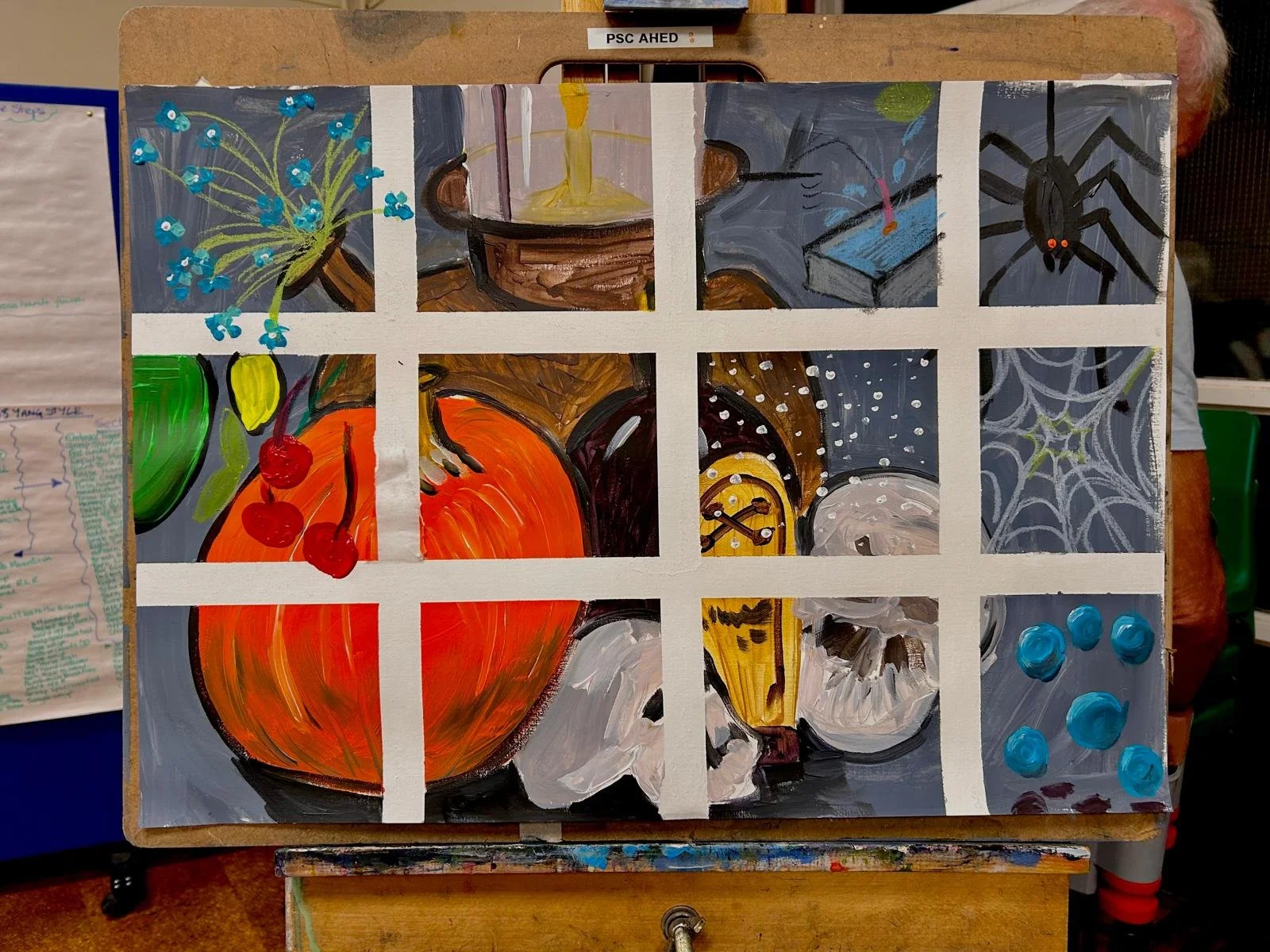 A collage of painted still life and nature scenes on a grid canvas, including a blue flower bouquet, a candle in a holder, a book with a spider running on its cover, a spider web, cherries with a green apple, a pumpkin, a clock, and berries.