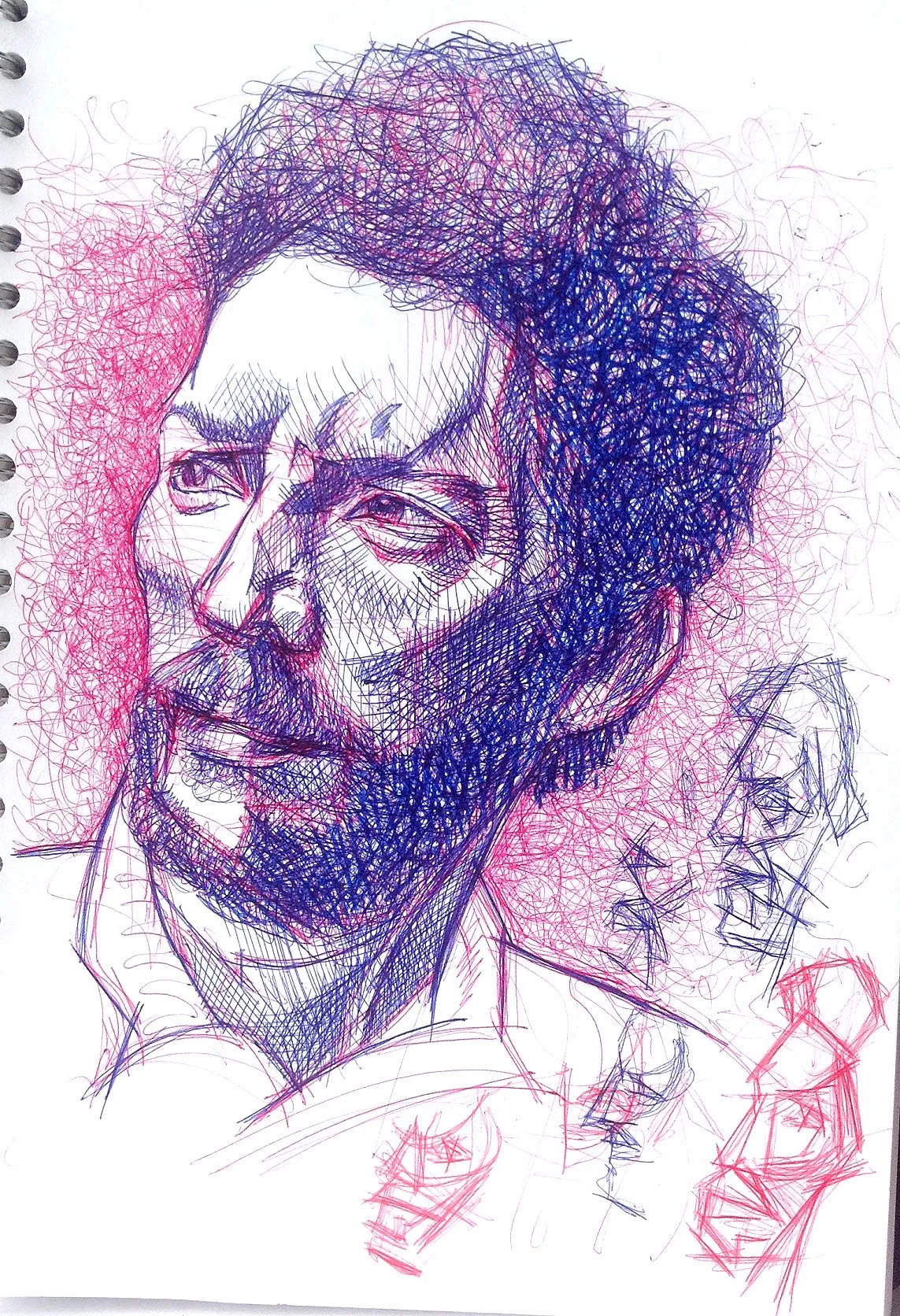 Ball point pen drawing of a man with curly hair, beard, and moustache, drawn with colourful scribbles in shades of blue, purple, and pink.