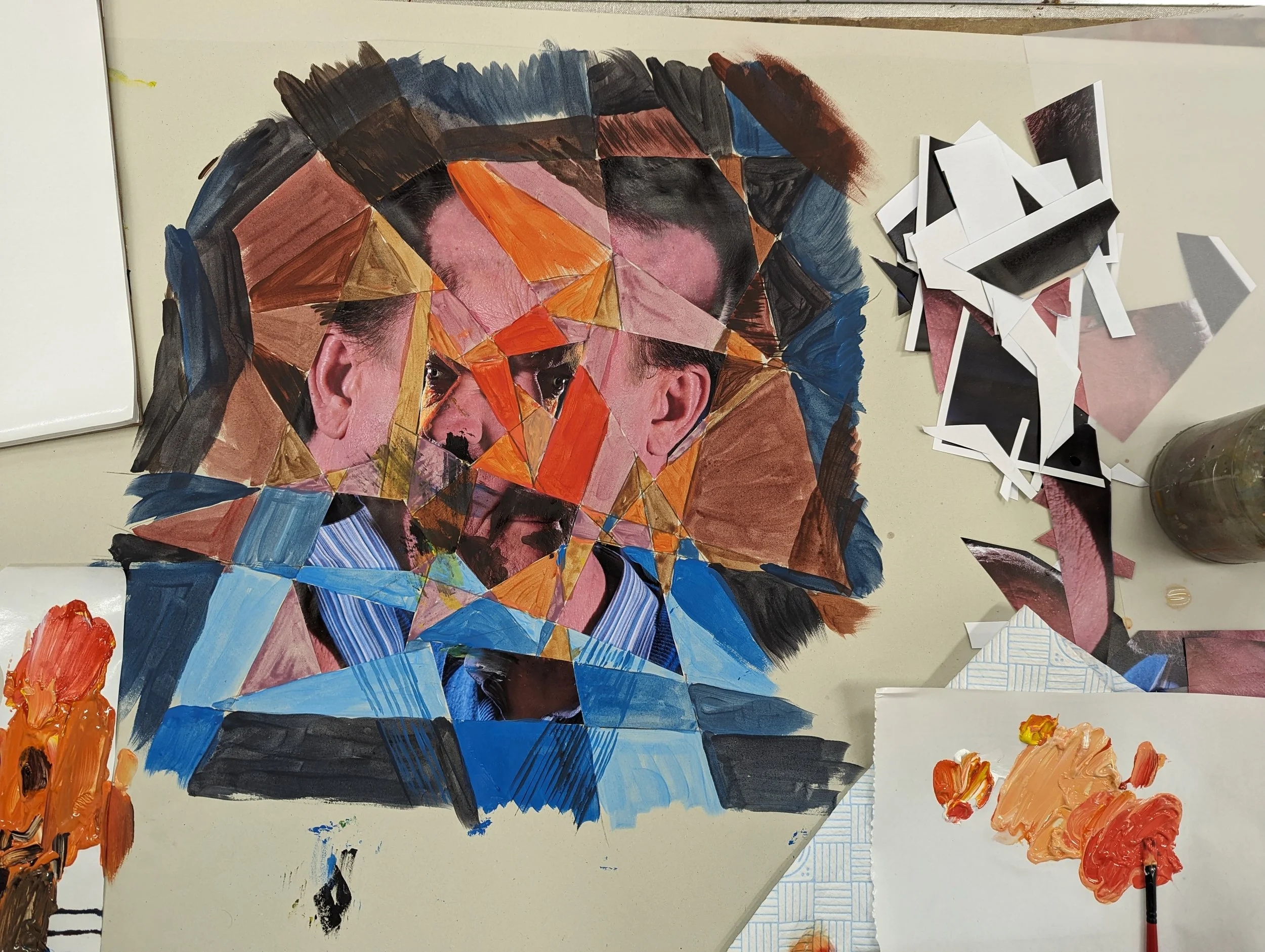 A mosaic portrait being created from cutout pieces of paper and painted sections