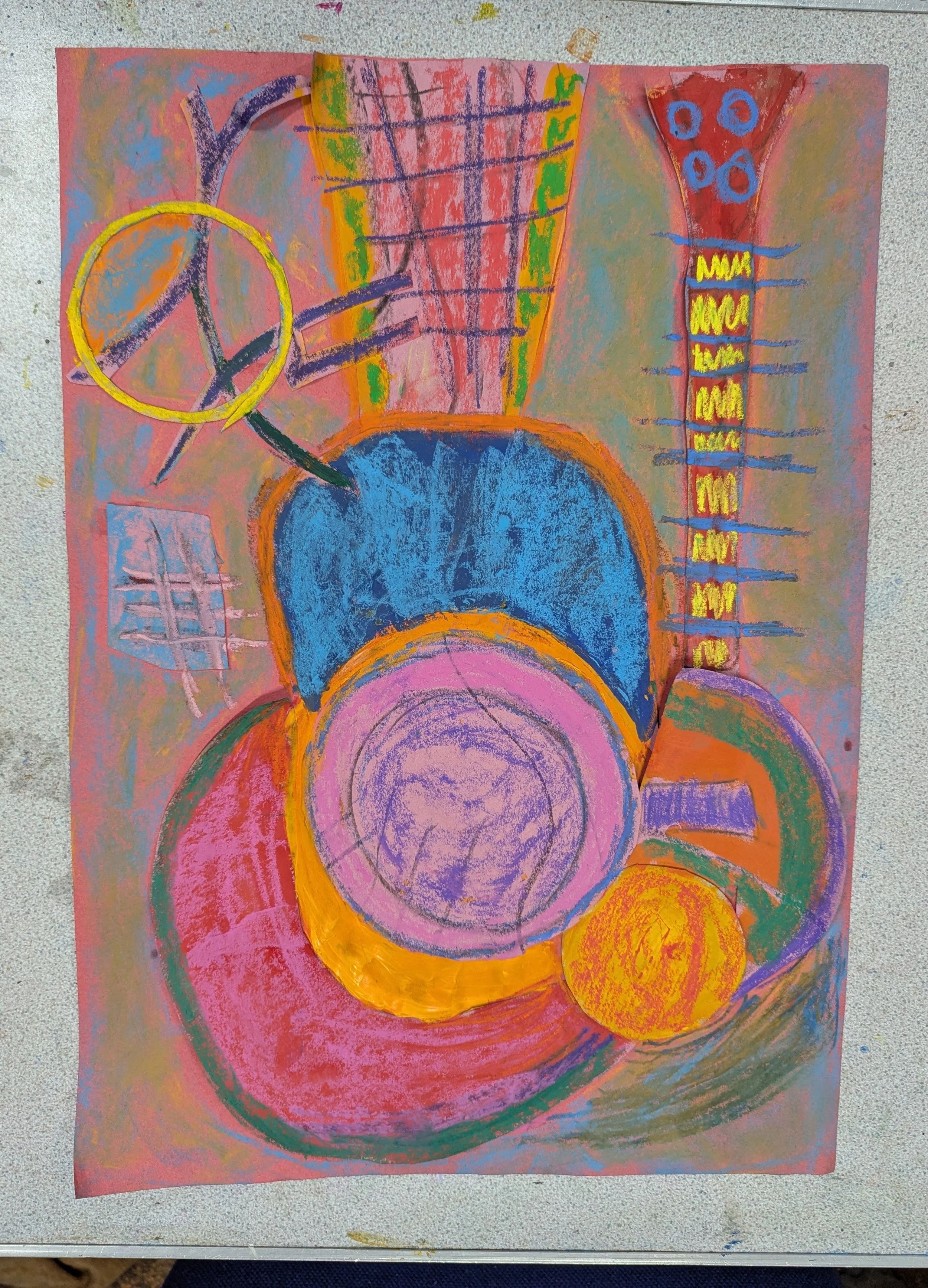 Colorful abstract drawing created with crayons or pastels, featuring various geometric shapes including circles, rectangles, and lines in bright colors such as blue, pink, orange, yellow, purple, and green.