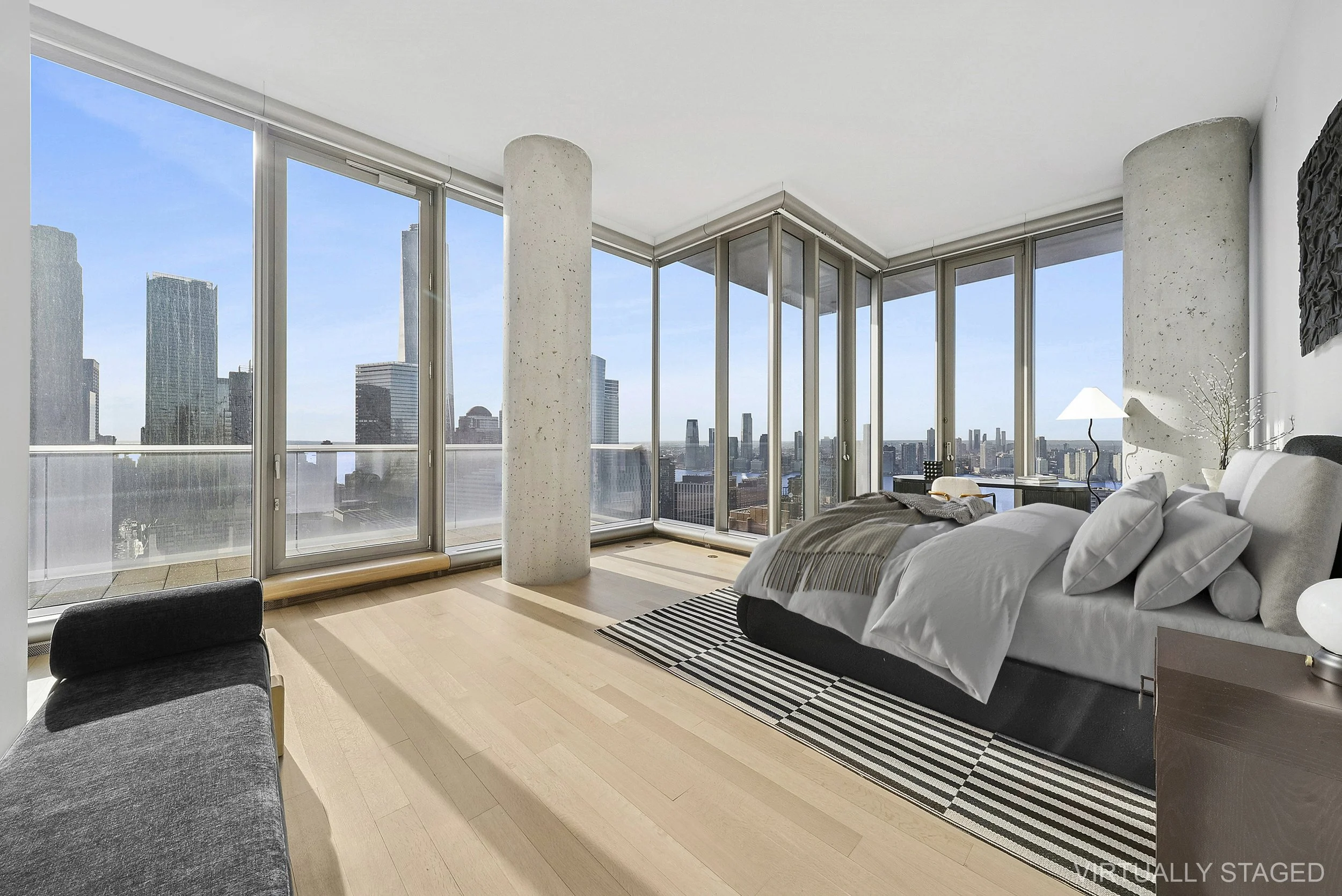 Modern bedroom with floor-to-ceiling windows showcasing a city skyline, a bed with white linens, and a black-and-white striped rug