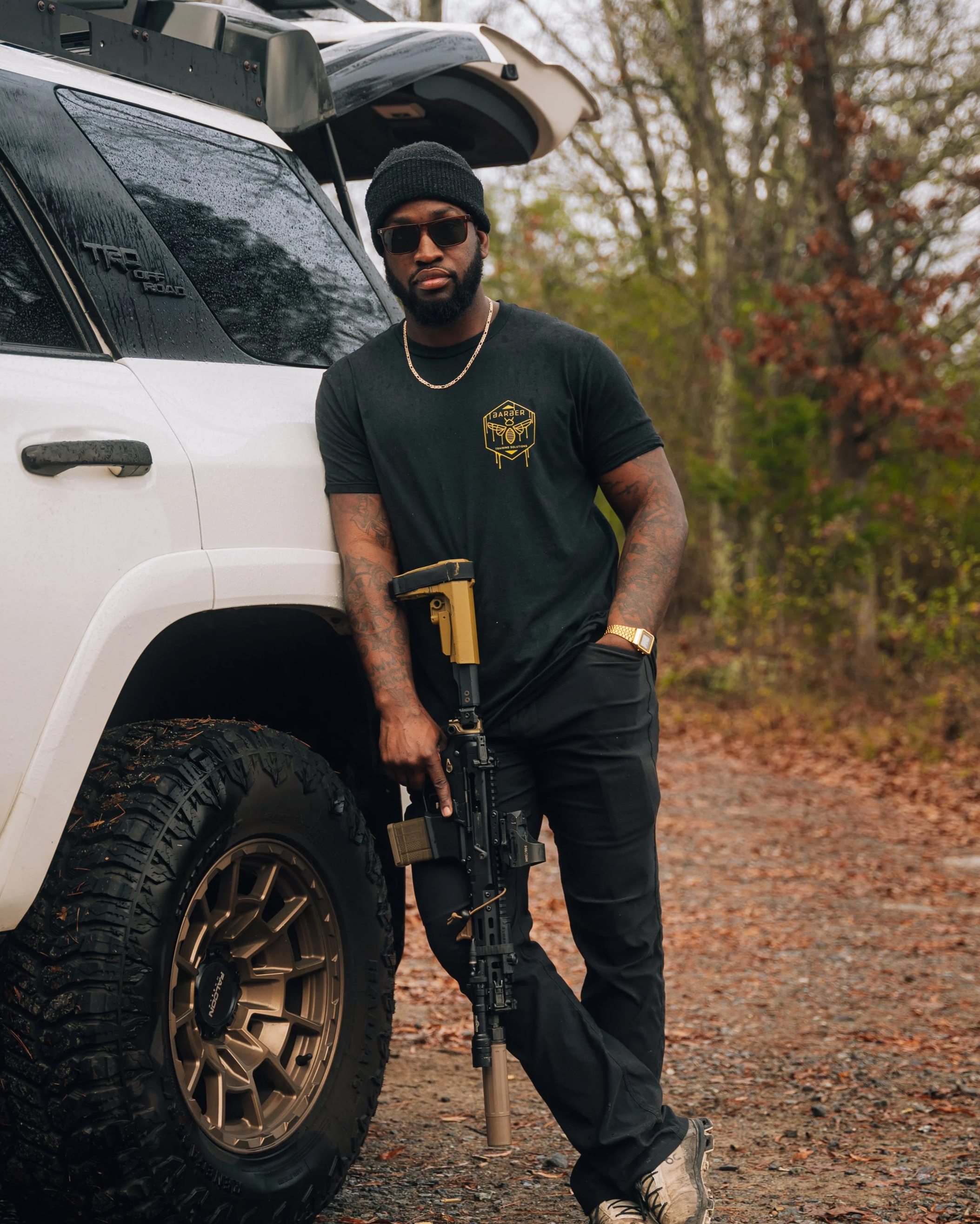 Man with a beard wearing a black cap holding a handgun. One of Arsenals Influencers/ Creators.