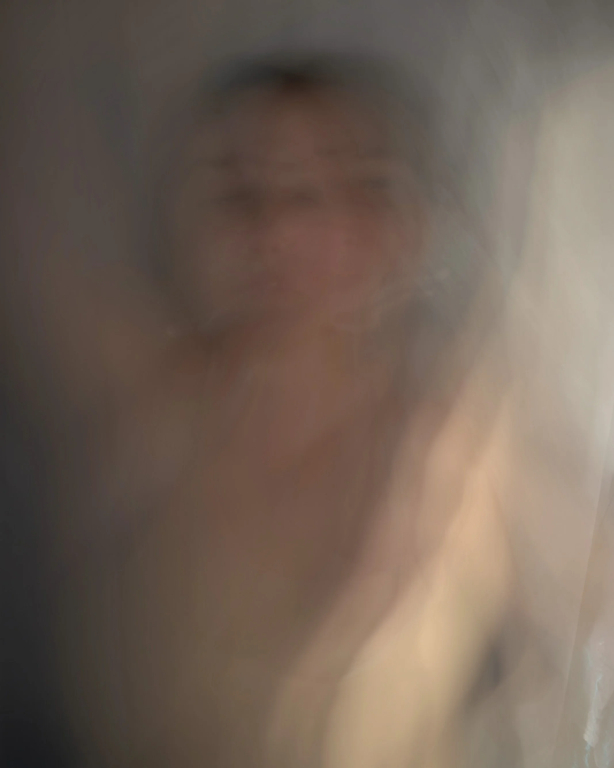 Udune kunstiline portree naisest pehme loori ja sooja valguse taga meditatiivse fotosessiooni ajal.