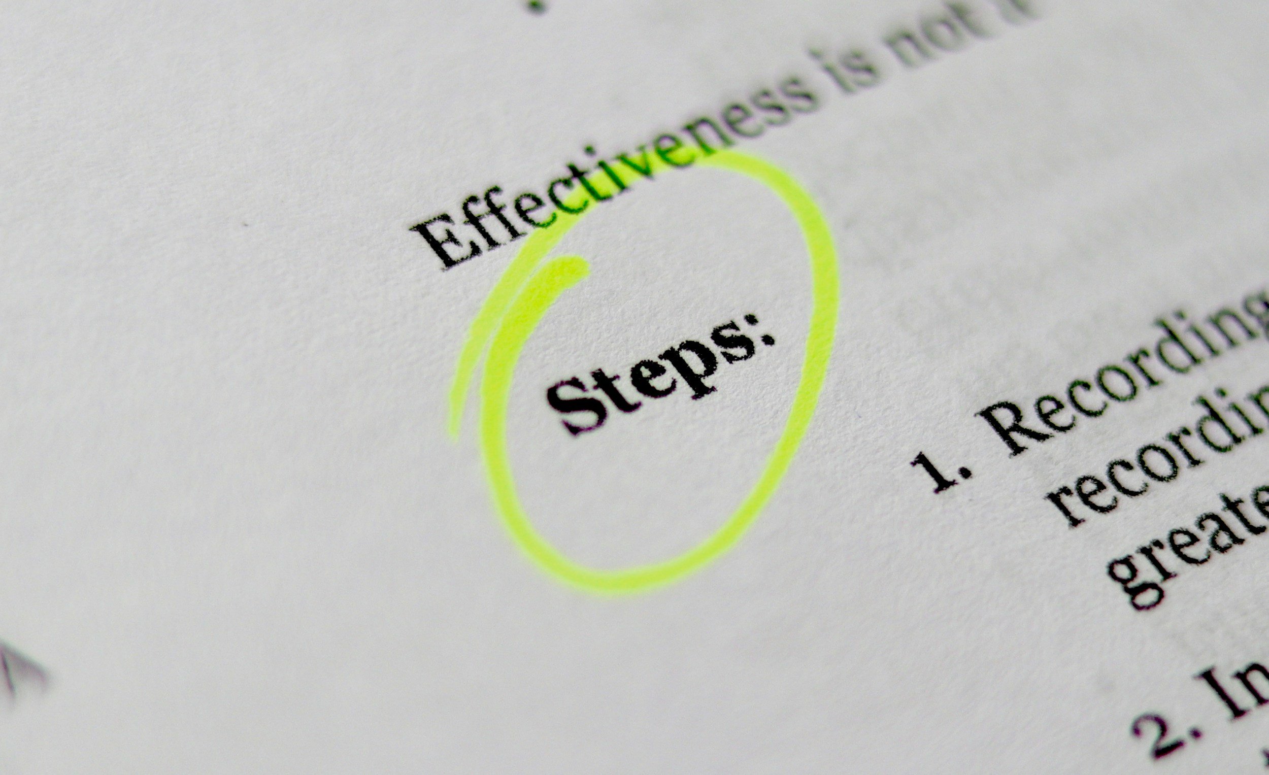 Close-up of a printed document highlighting the word 'Steps!' and 'Effectiveness', with a yellow circle around 'Steps!'.