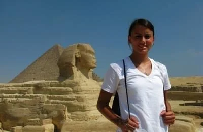 Young woman standing in front of the Great Sphinx of Giza in Egypt.
