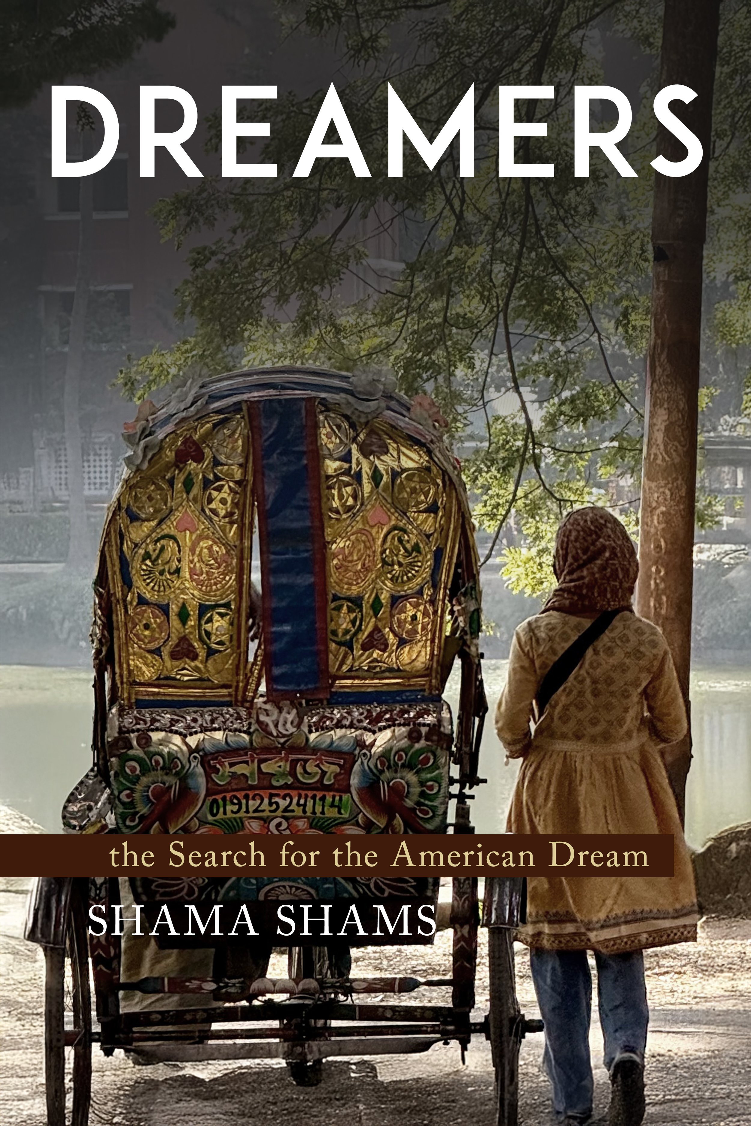 A woman walking beside a decorated rickshaw by a river, with trees and buildings in the background, during daylight.