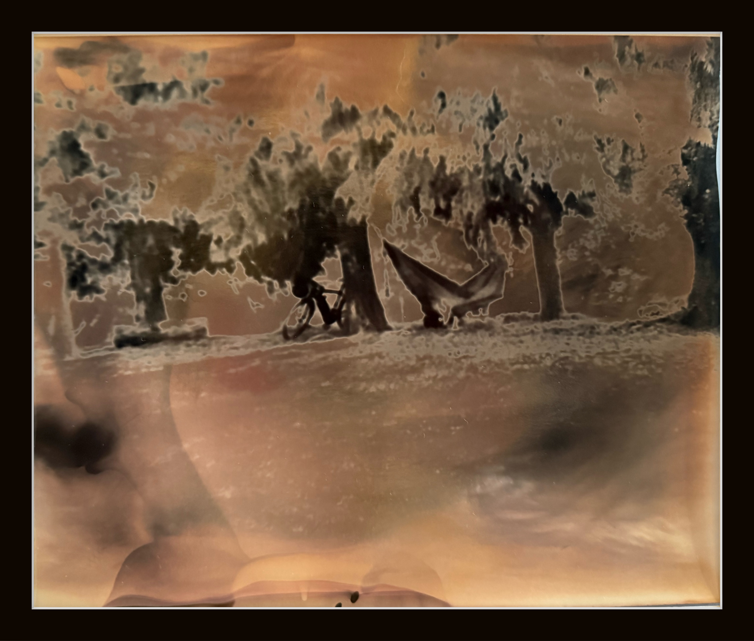 Abstract image with brown and black smoky patterns and a faint outline of a person riding a bicycle.