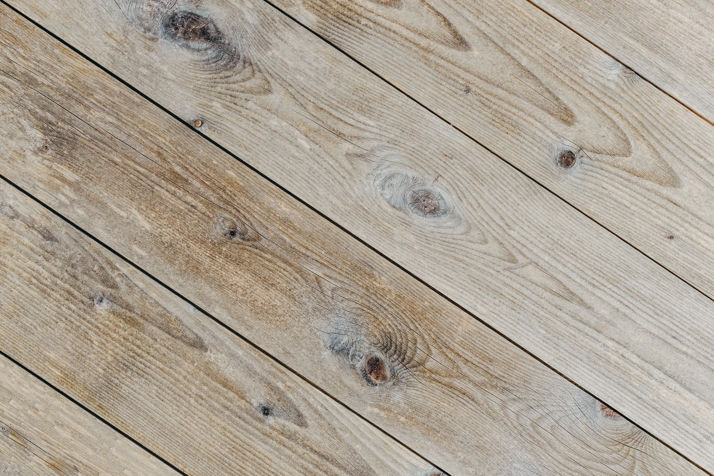 Close-up view of light-colored wooden floorboards with visible wood grain and knots.