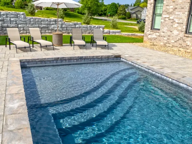 Storm Grey fiberglass pool color with modern landscaping