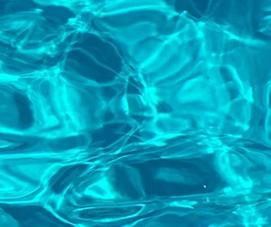 Clear blue swimming pool water with reflections.
