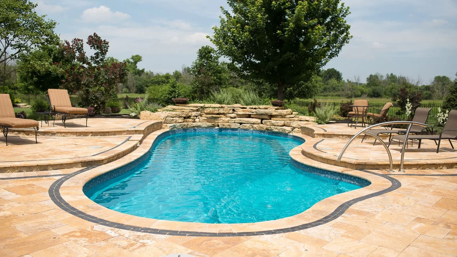 Agave Pool Company freeform fiberglass pool in East Texas with splash pad entry, wide steps, and large swim area for entertaining and relaxation.