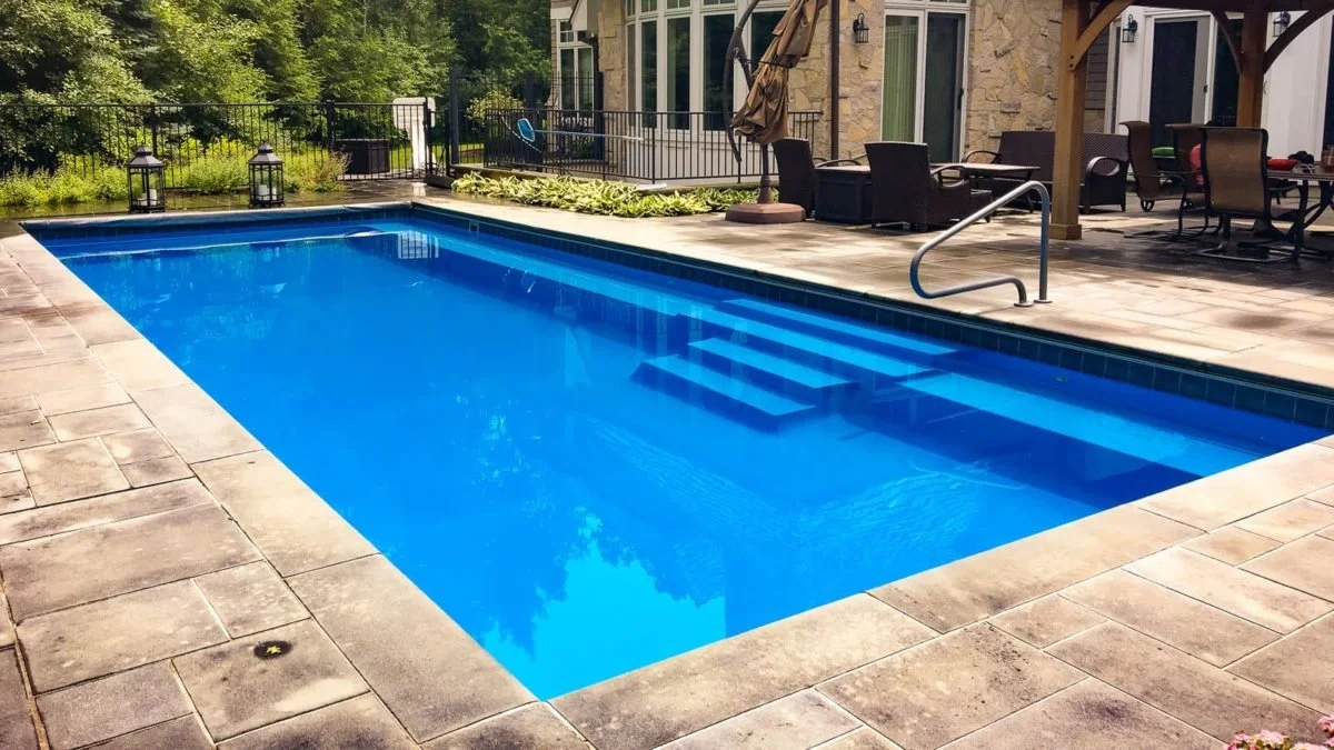 Agave Pool Company long fiberglass pool with end-to-end swim lane and full-length bench seating for relaxation and entertaining.