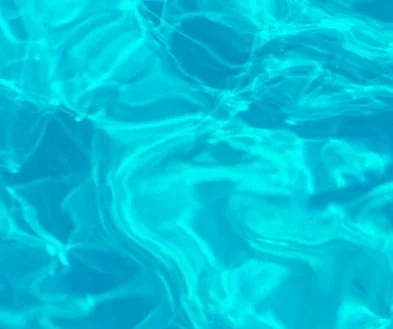 Close-up of clear blue swimming pool water with reflections.