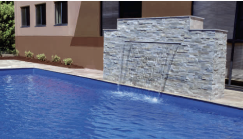 Modern outdoor pool with a stone waterfall feature