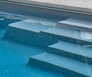 Close-up of pool steps submerged underwater.